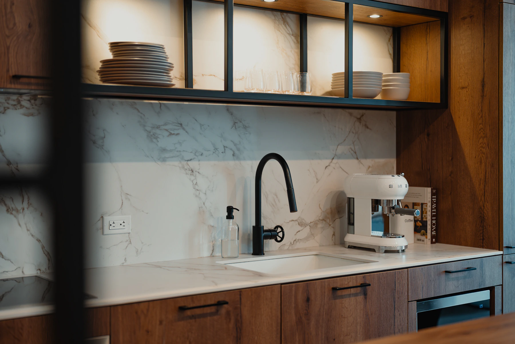 Espresso machine and kitchen appliances beside a modern kitchen sink