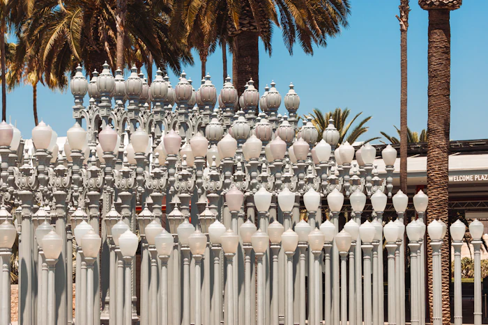Rows of vintage streetlamps with palm trees behind