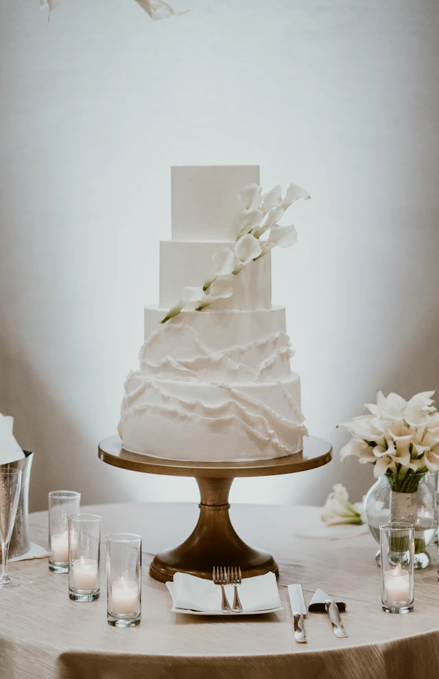 Elegant wedding cake with soft buttercream, flowers, and dessert table styling for modern cake ideas