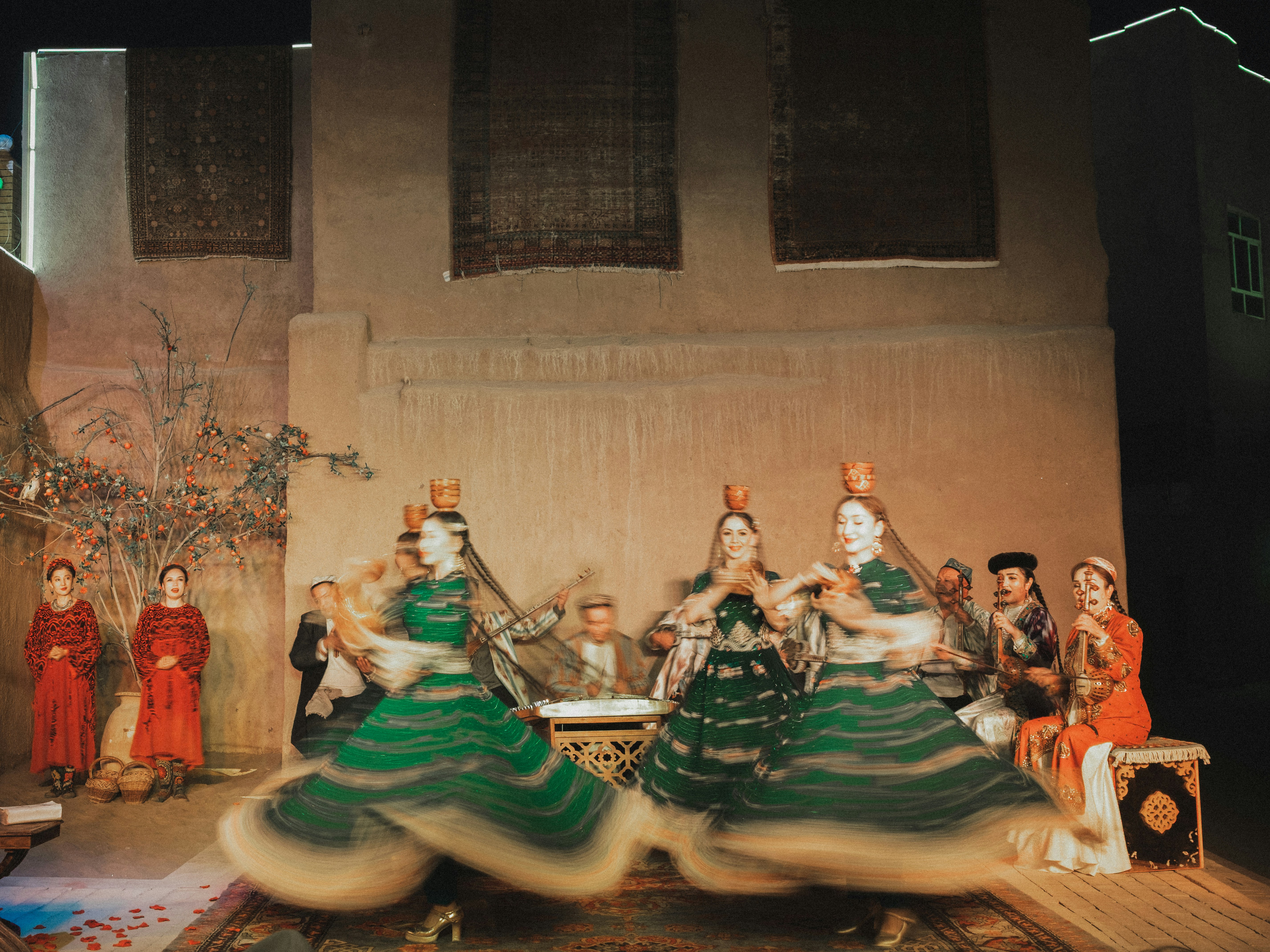 Dancers in green dresses perform on stage.