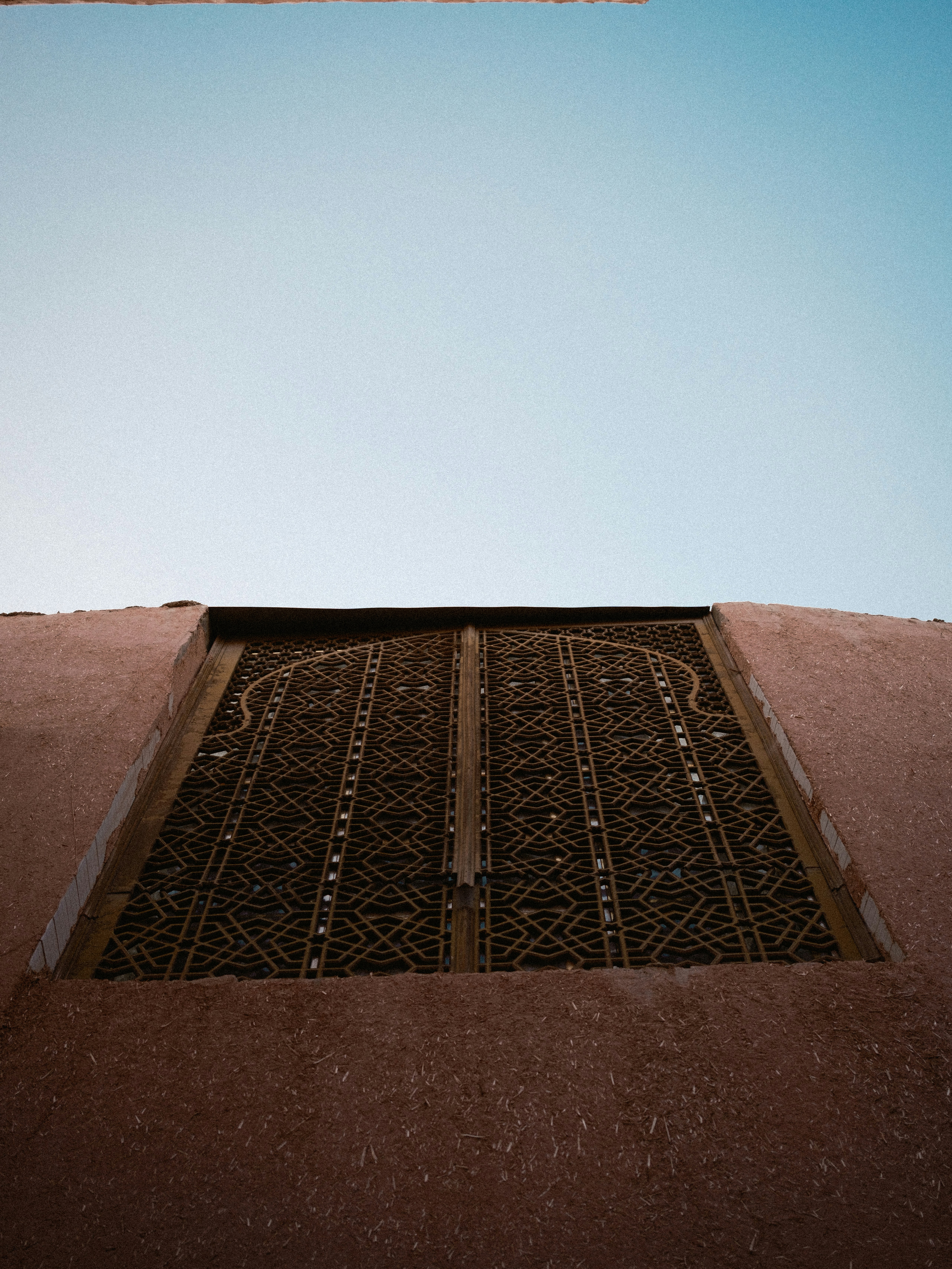 Ornate metal gate against a clear blue sky