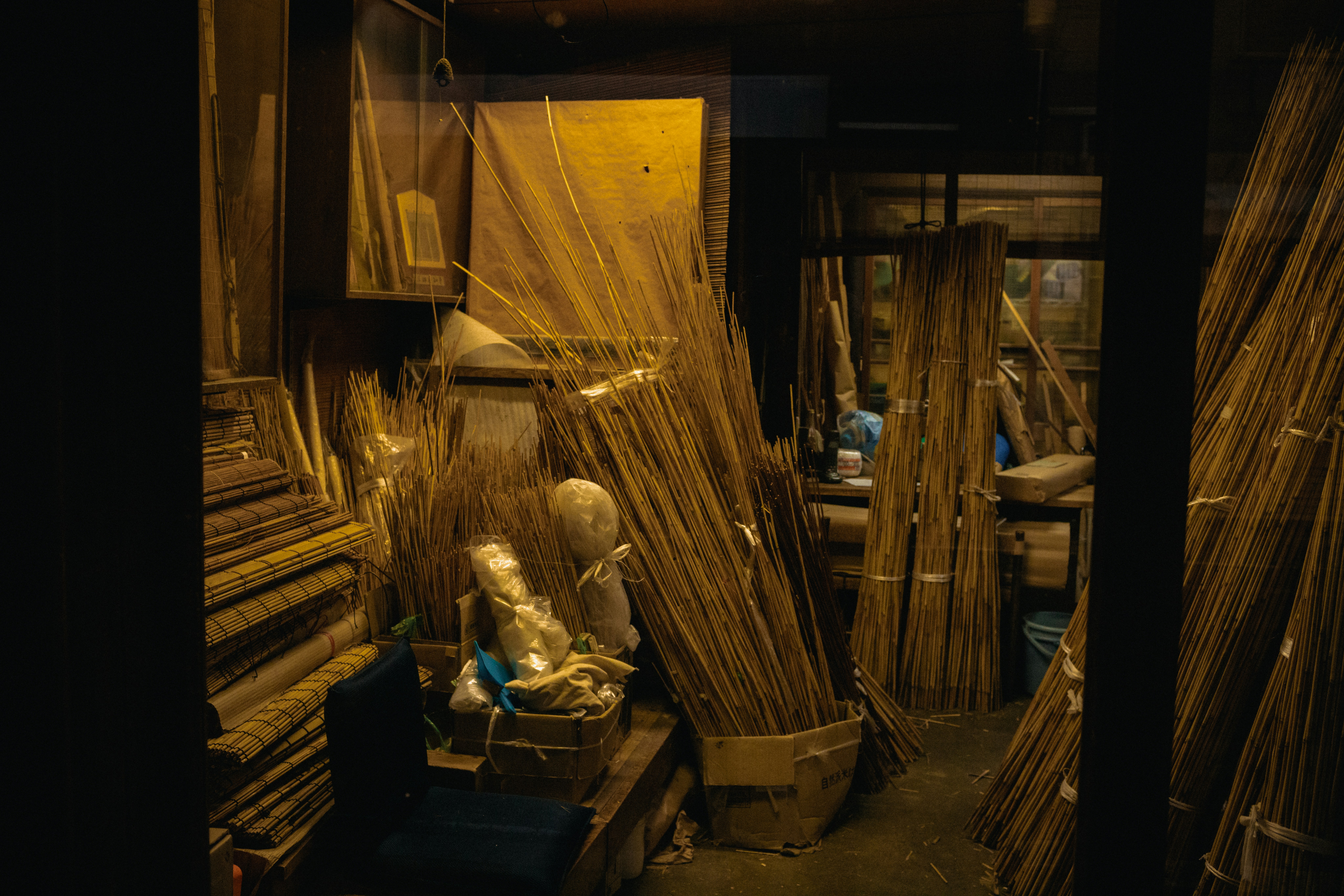 Bundles of dried reeds and wooden frames in a workshop.