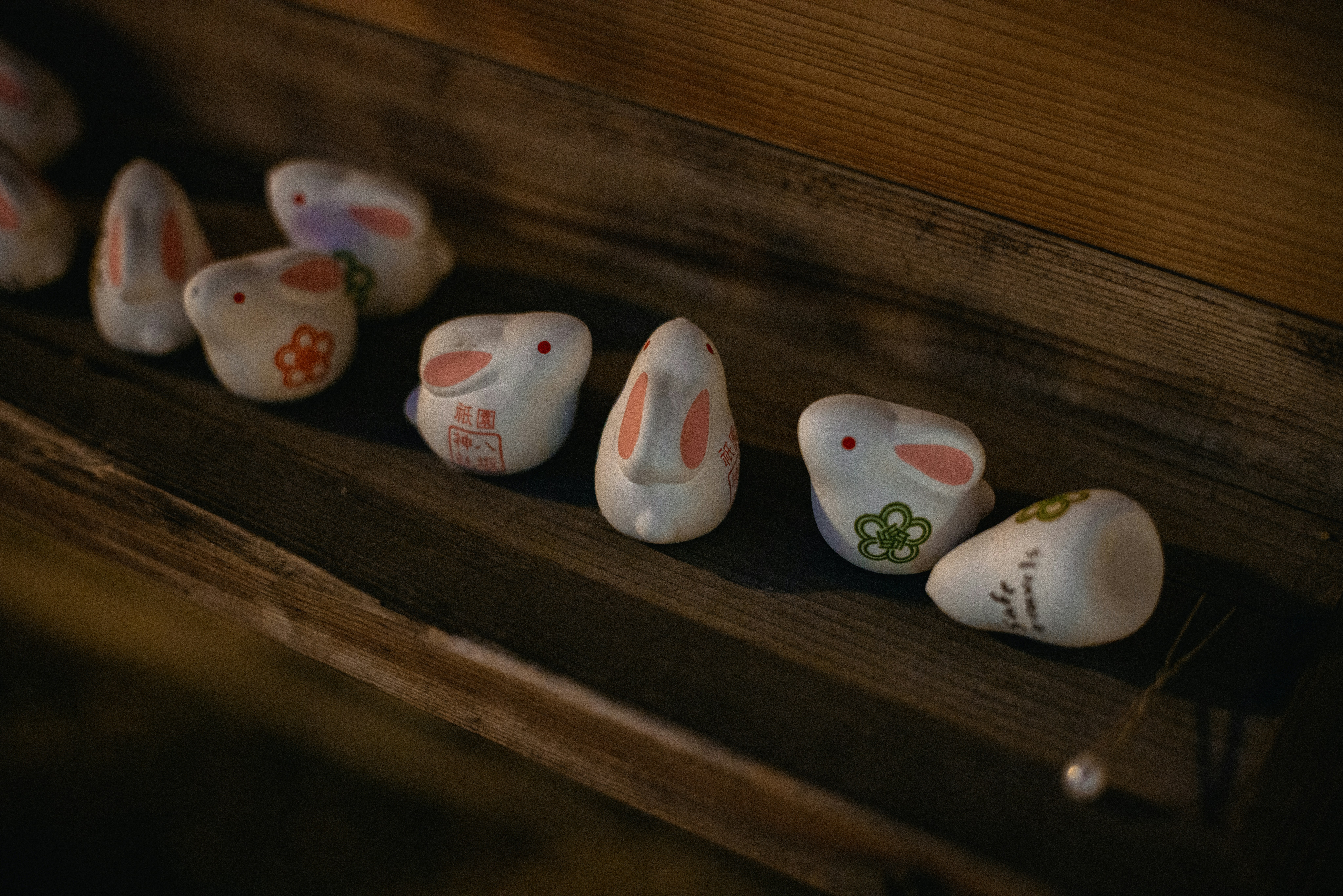 Small ceramic bunnies with floral designs displayed on wood