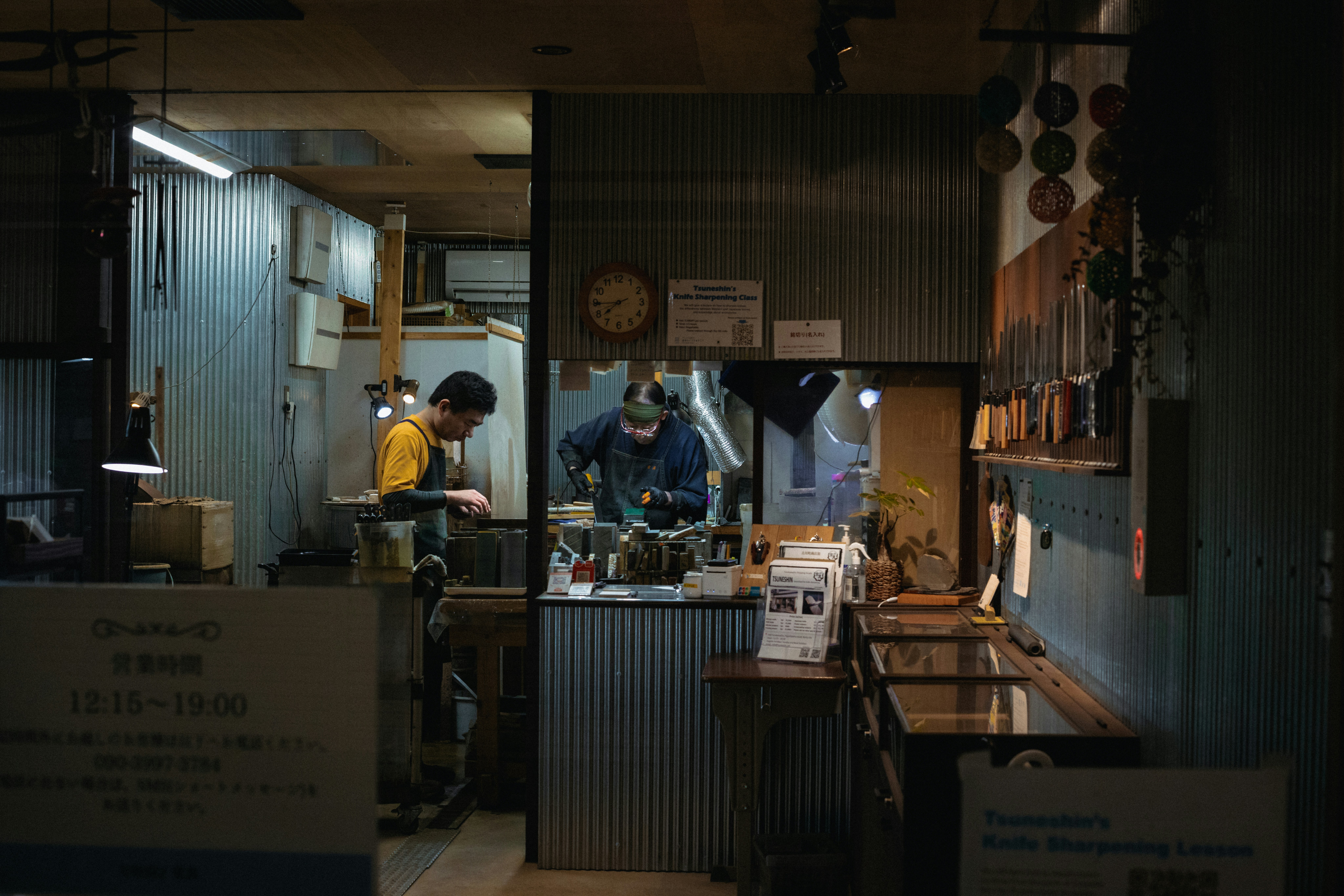 Two people working in a dimly lit workshop