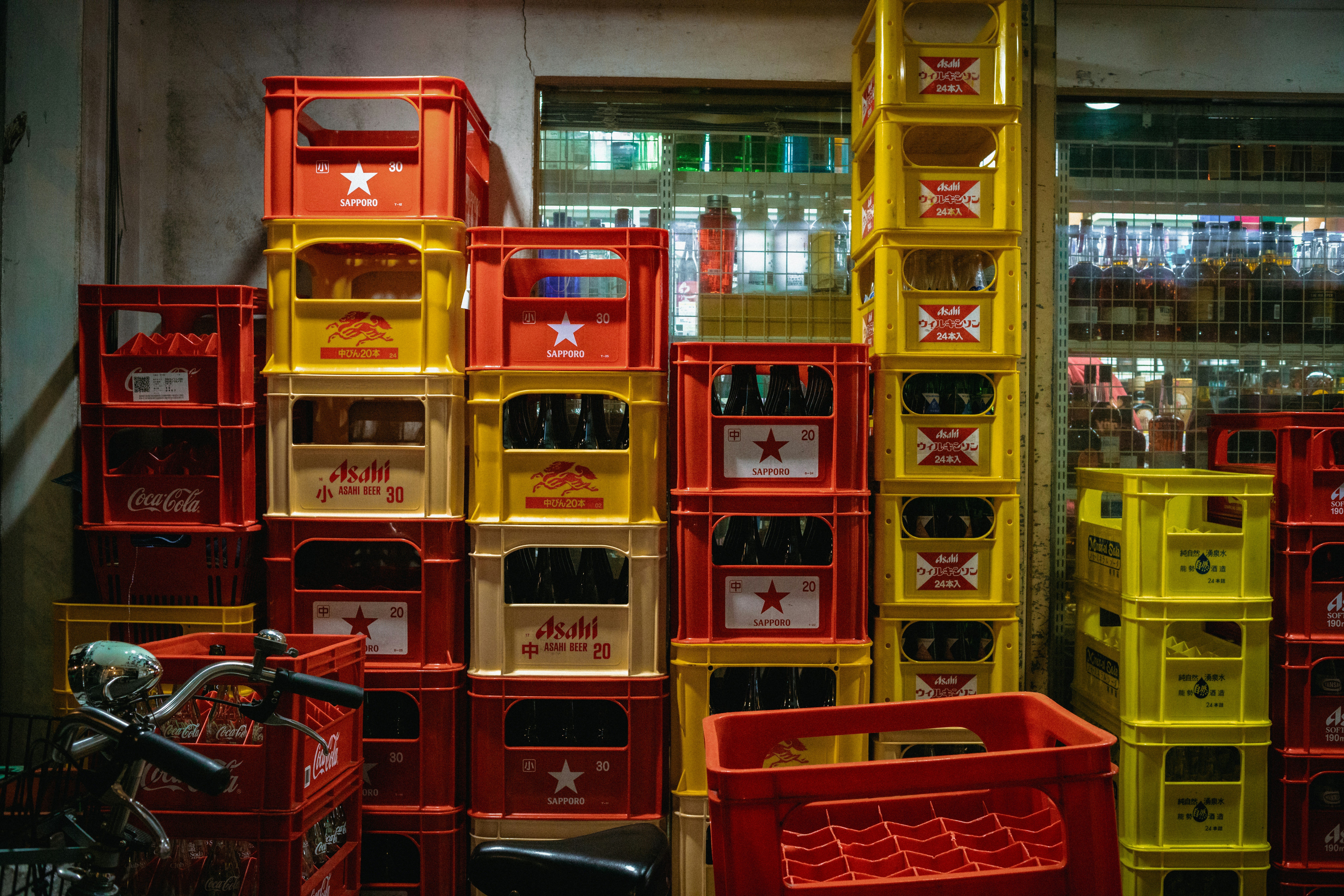 Stacks of red and yellow crates filled with bottles.