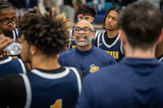 Coach giving instructions to basketball players during a huddle.
