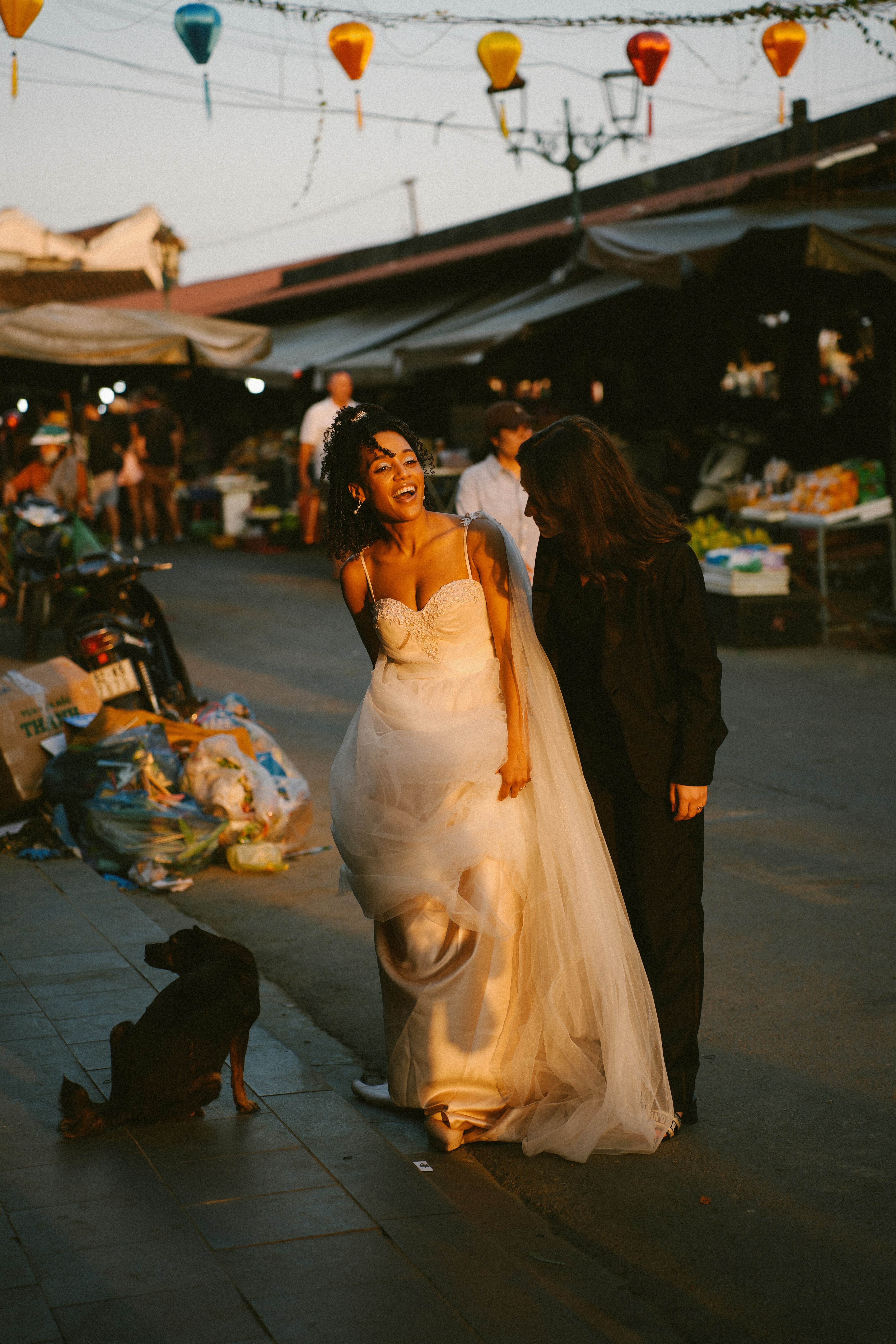 Bride laughing with a companion on a street