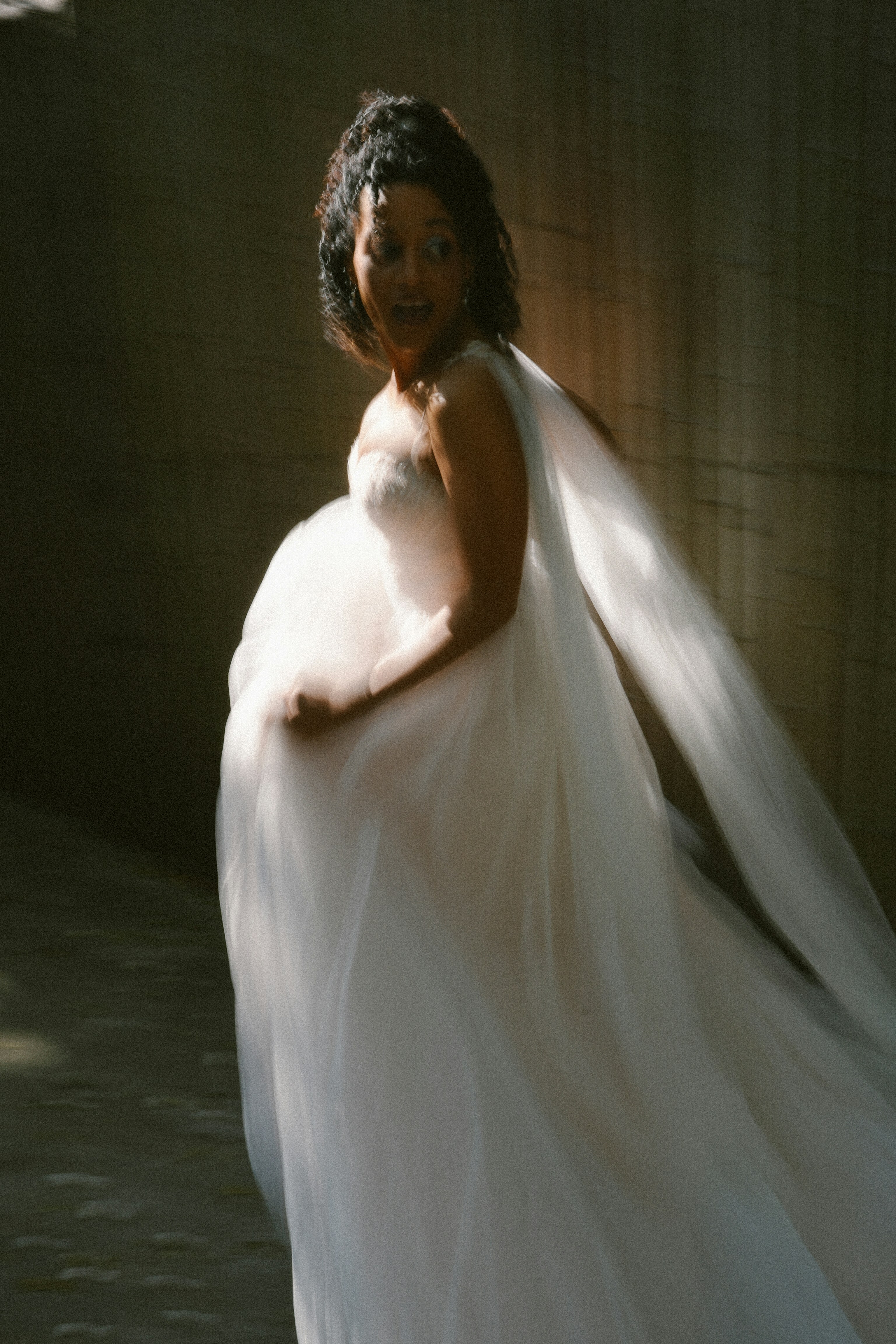 Una donna incinta in un abito bianco fluente