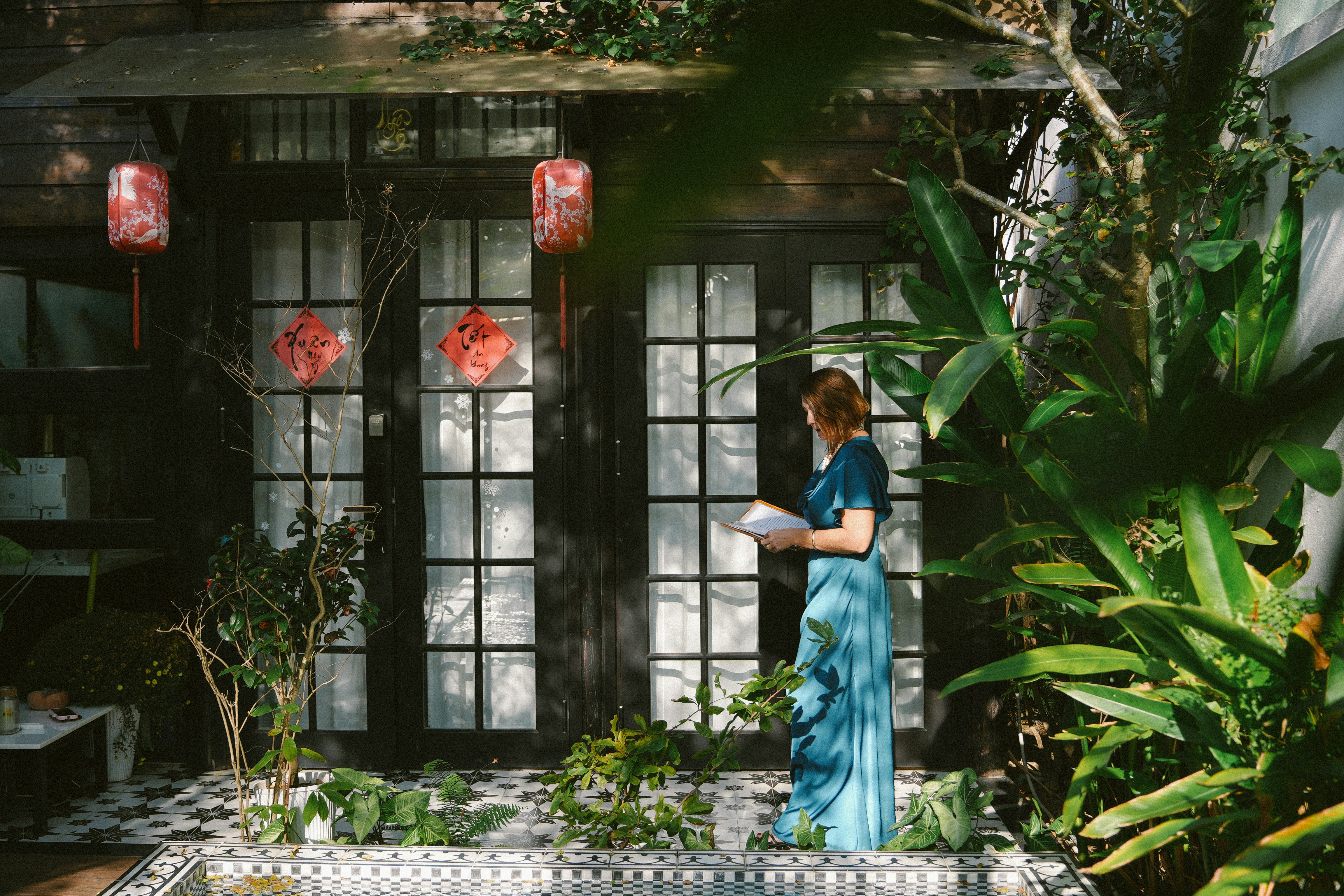 Donna in abito blu in piedi vicino a una finestra