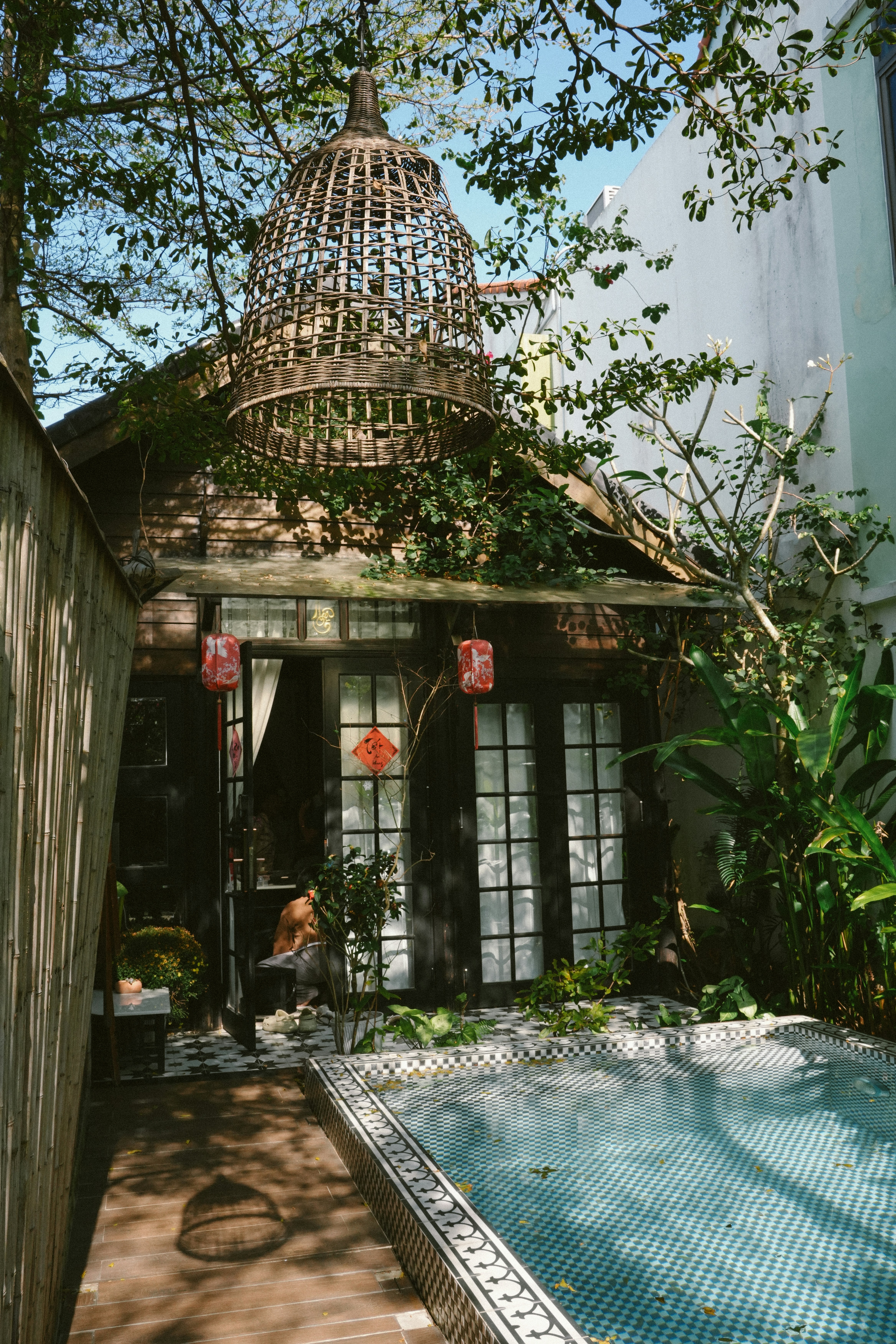 Piccolo giardino sul retro con una piscina e una gabbia per uccelli ornata