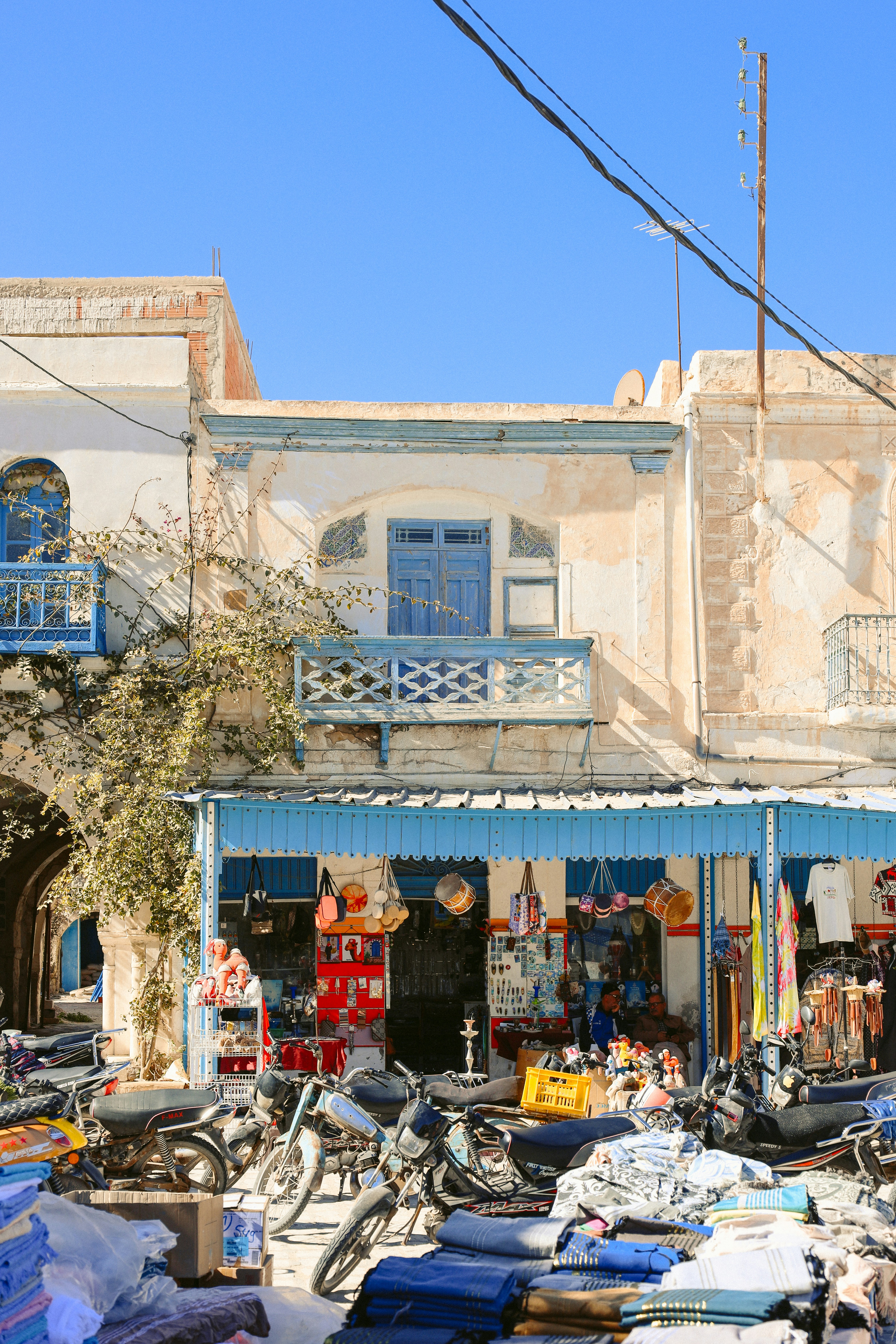 Motorräder parkten vor einem belebten Marktstand.