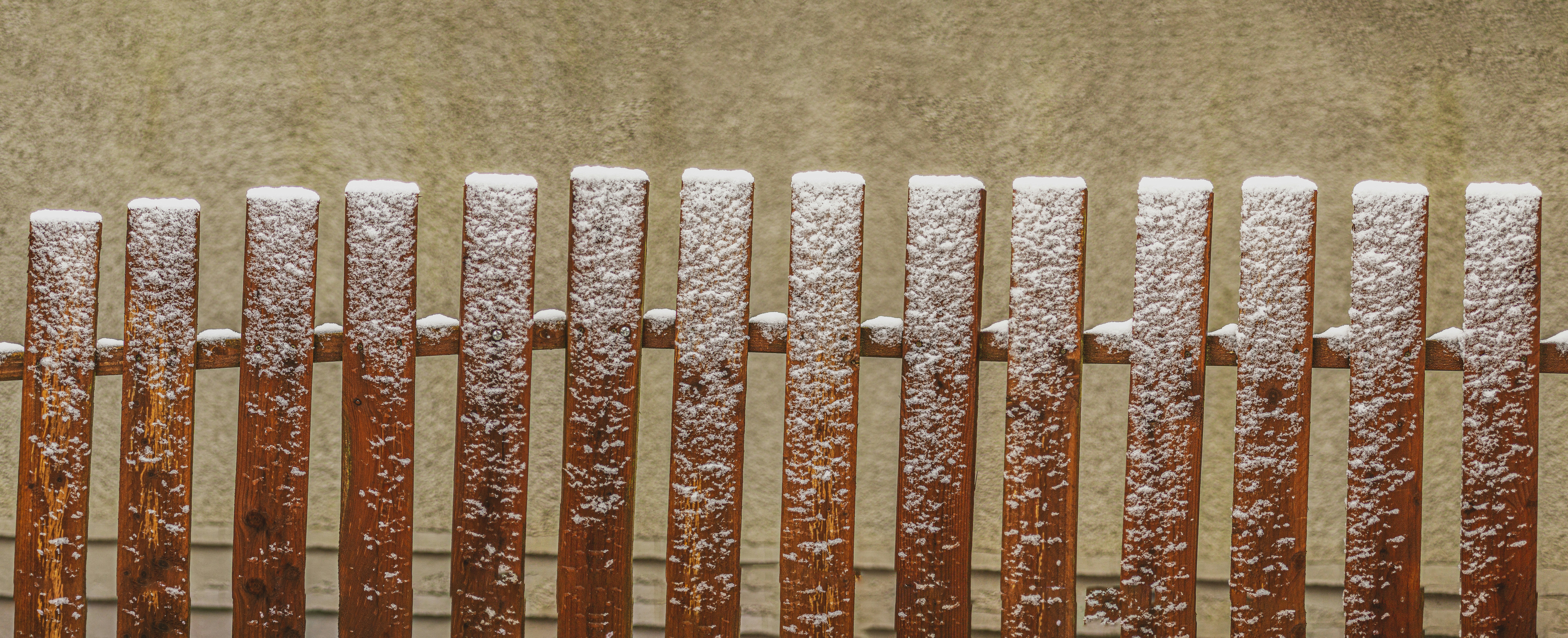 Holzzaunpfähle, bedeckt mit frischem Schnee
