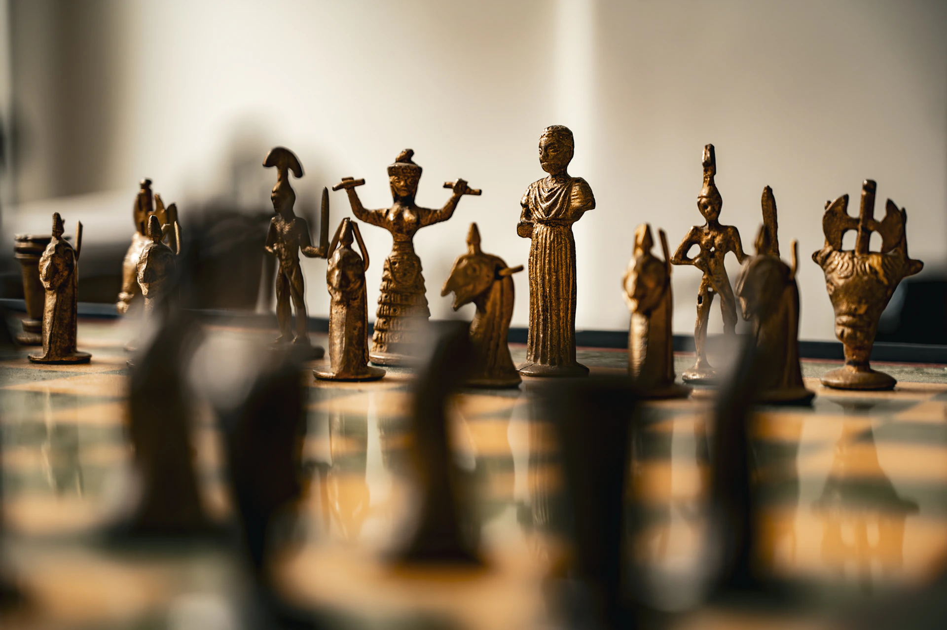 Antique bronze chess pieces arranged on a board.