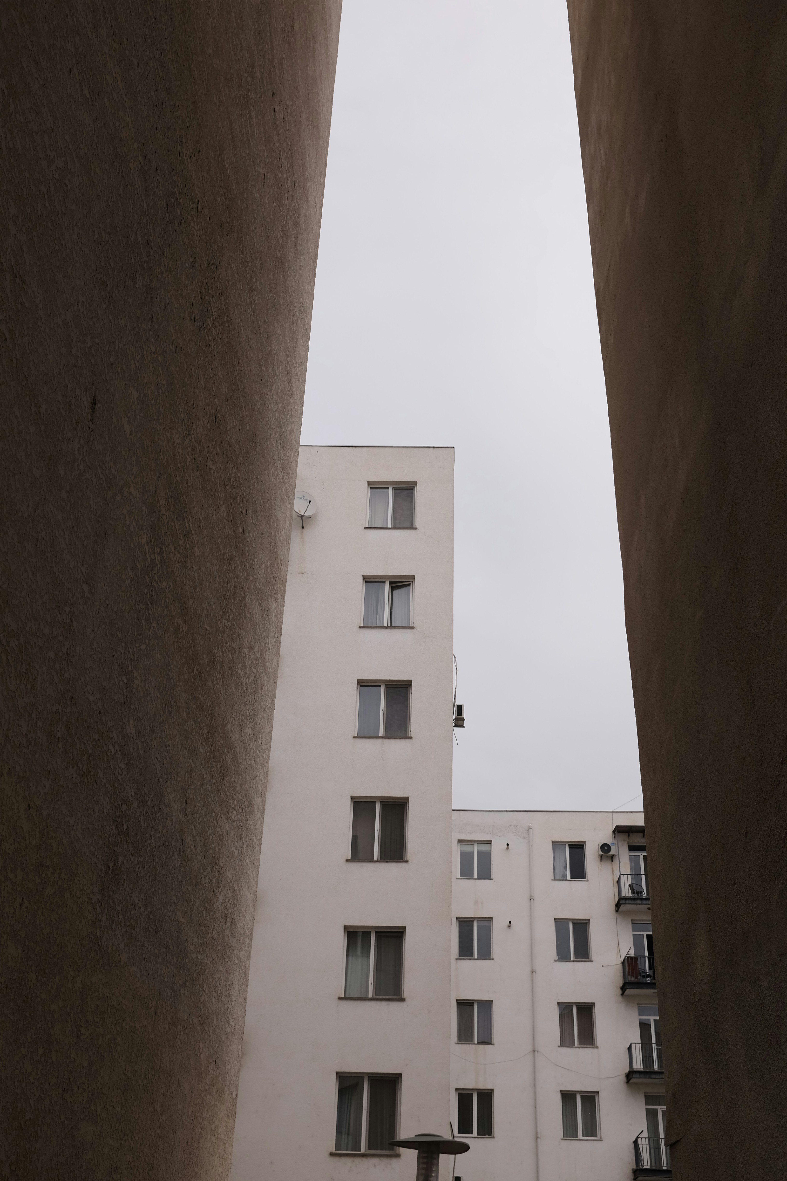 Two buildings seen between two walls
