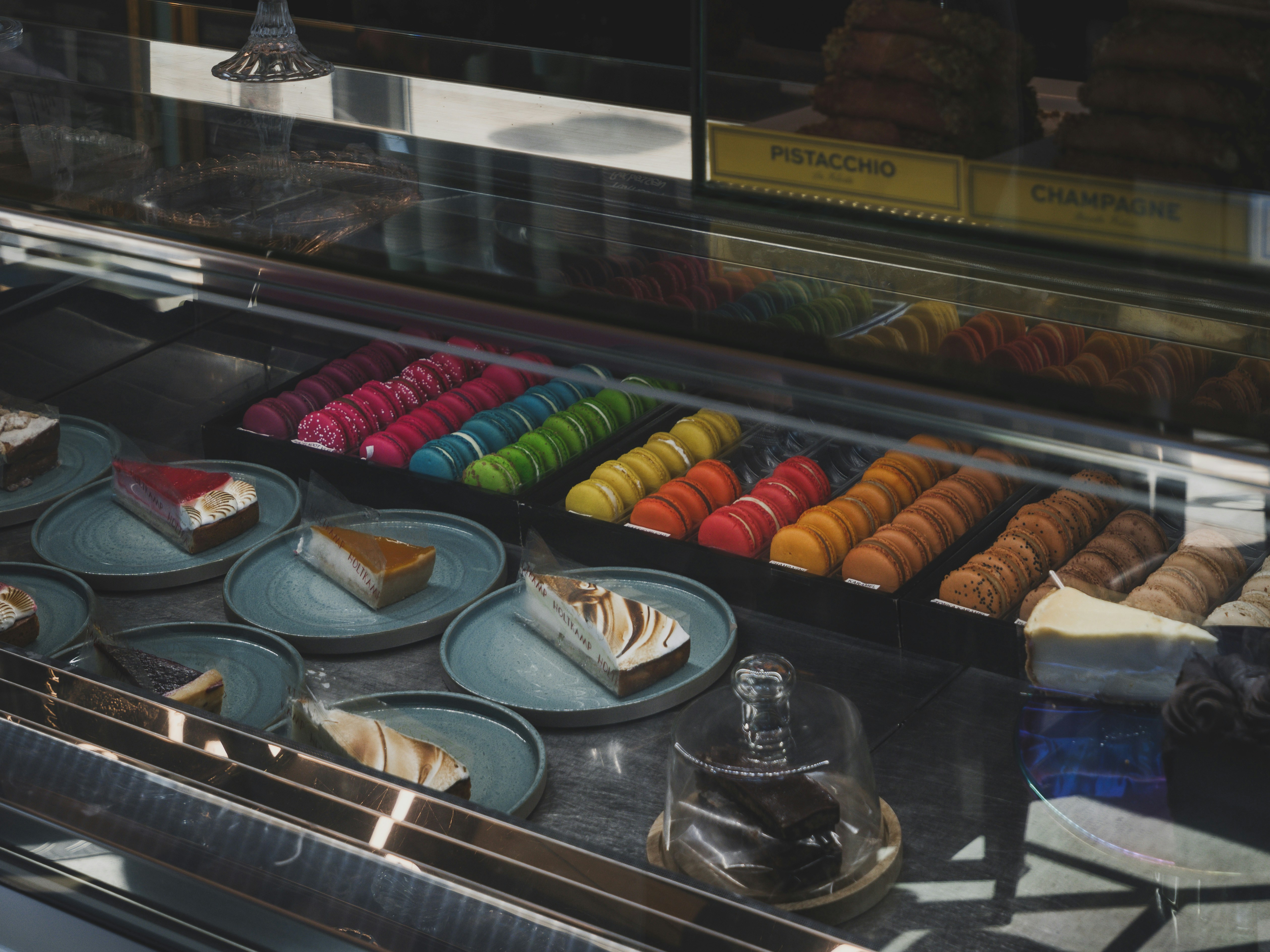 Macarons coloridos y rebanadas de pastel en una vitrina