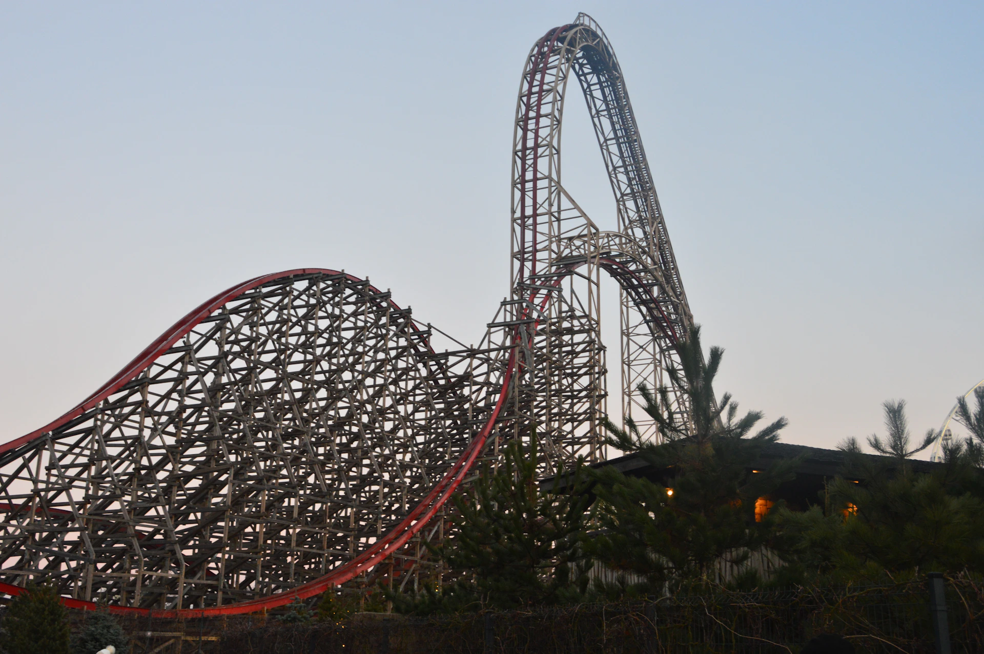 A towering wooden roller coaster against a pale sky