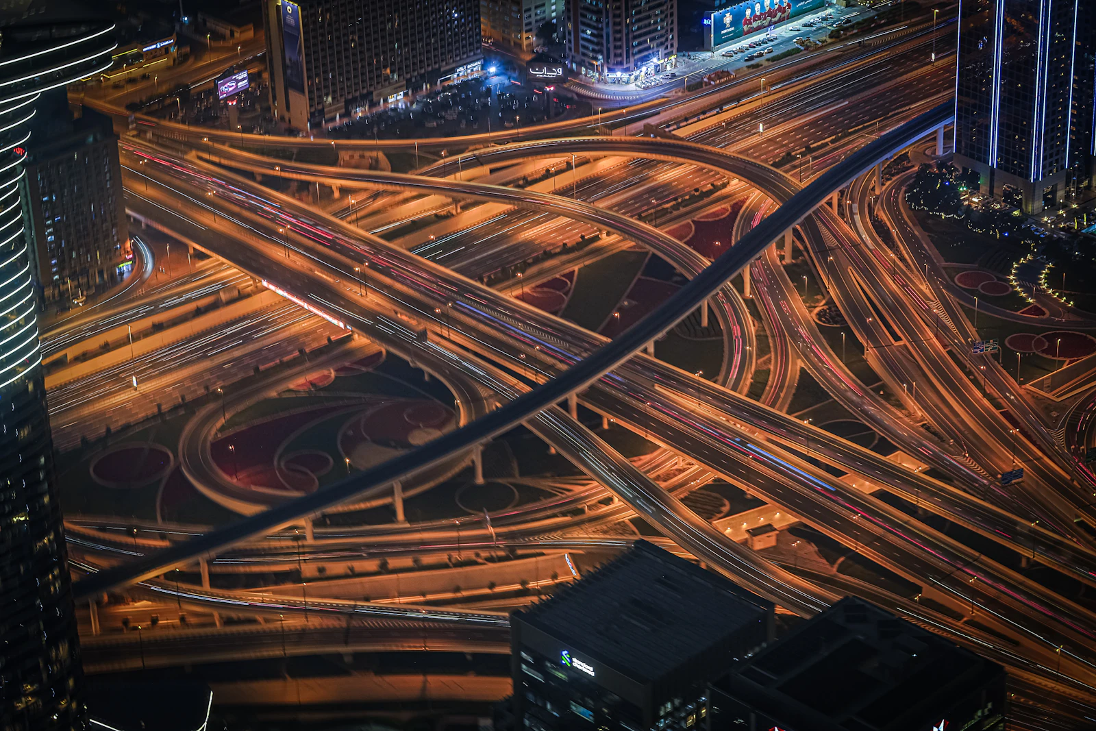 Aerial view of a busy multi-lane highway interchange at night with light trails — capital routed across four pathways through SCOPE Cascade