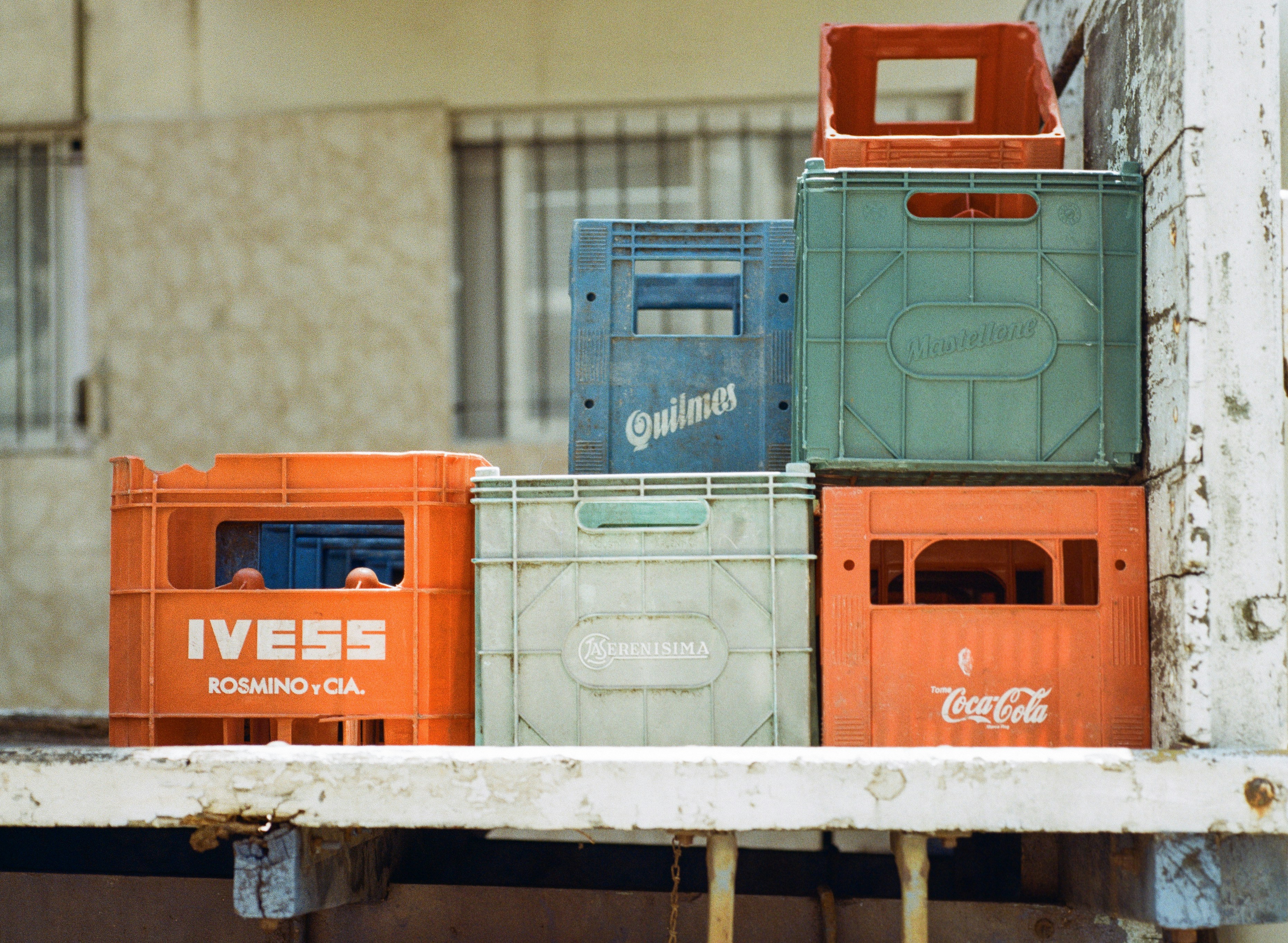 Stack of colorful plastic crates with logos.