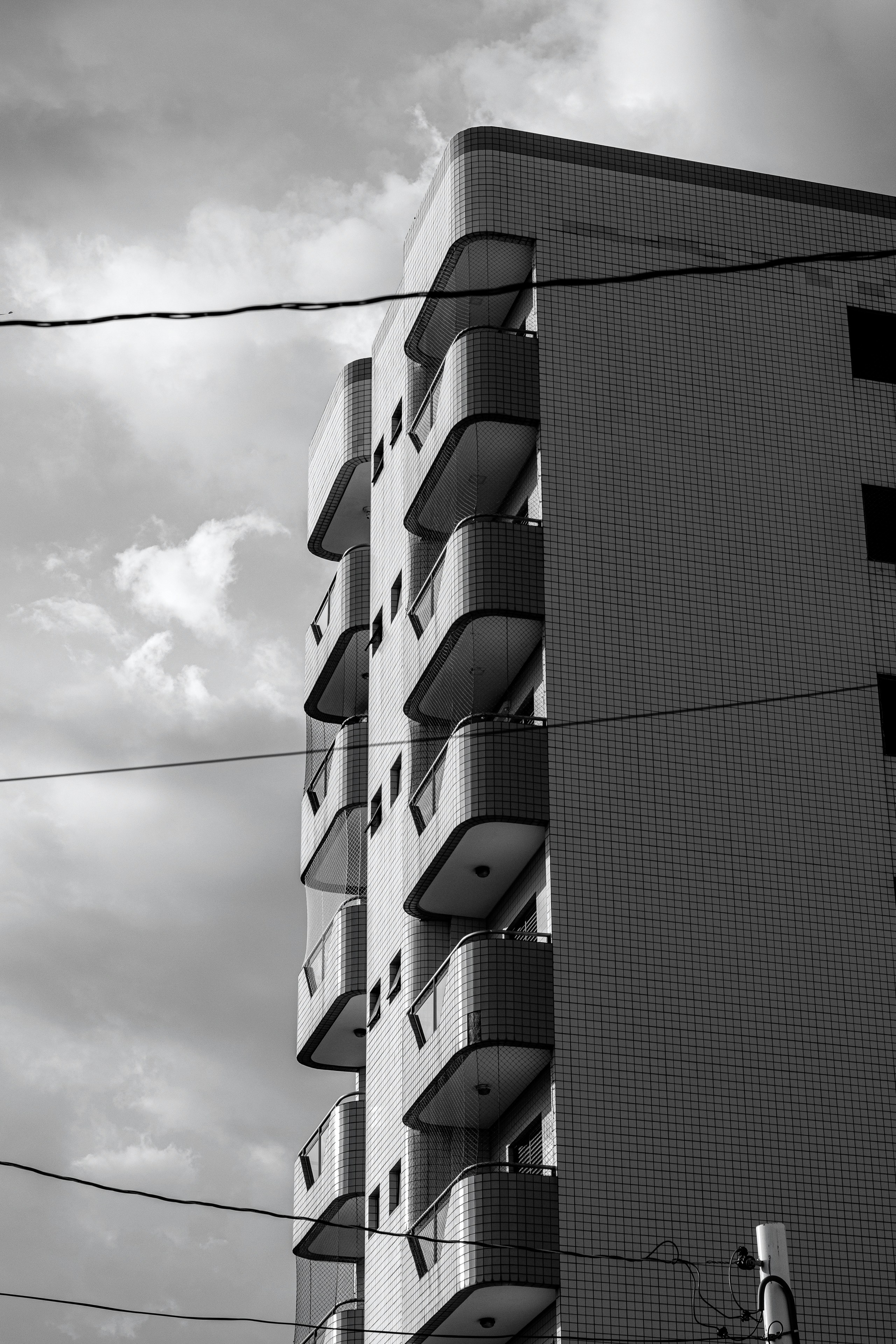 Tall building with balconies against a cloudy sky