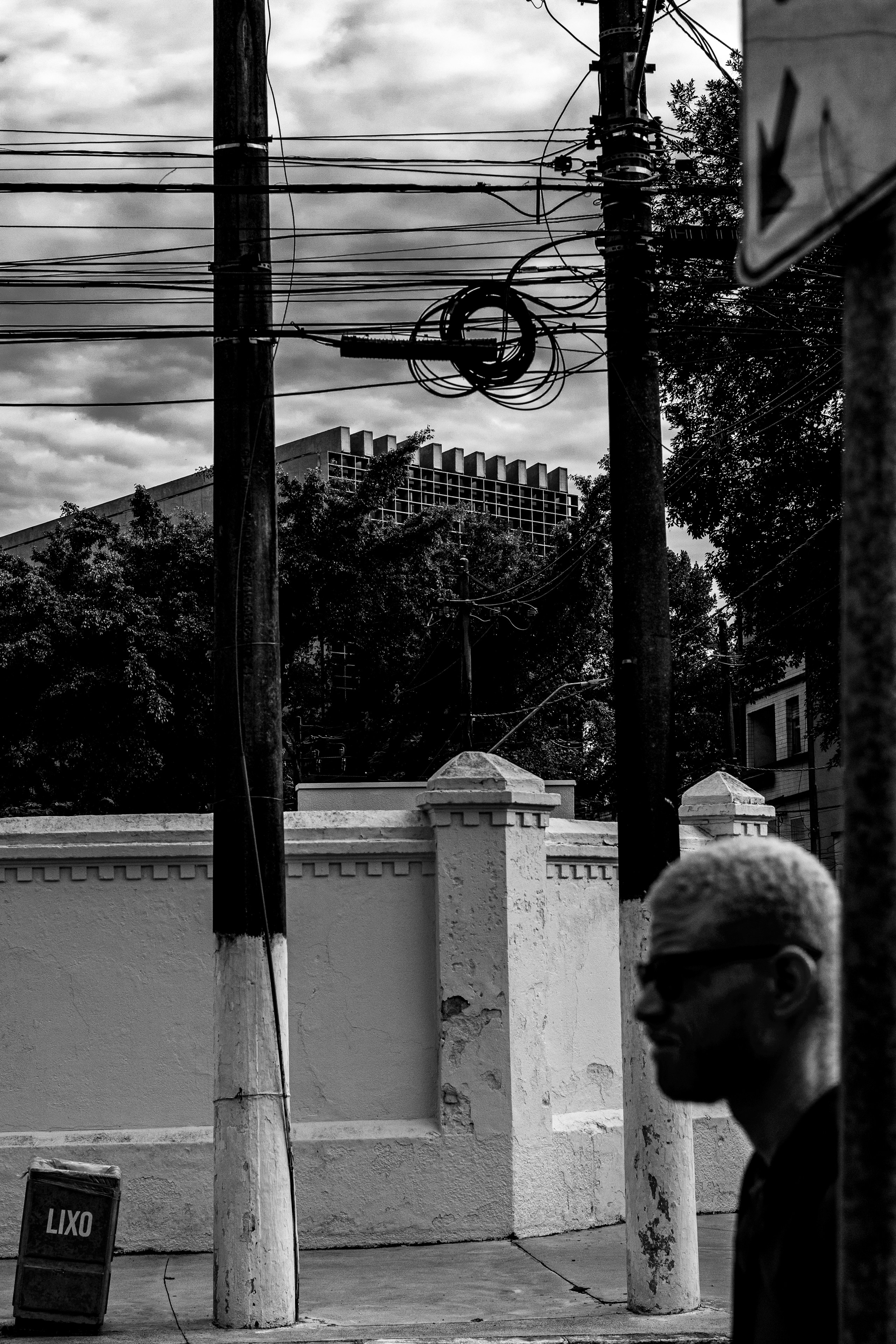 Man walks past utility poles and building