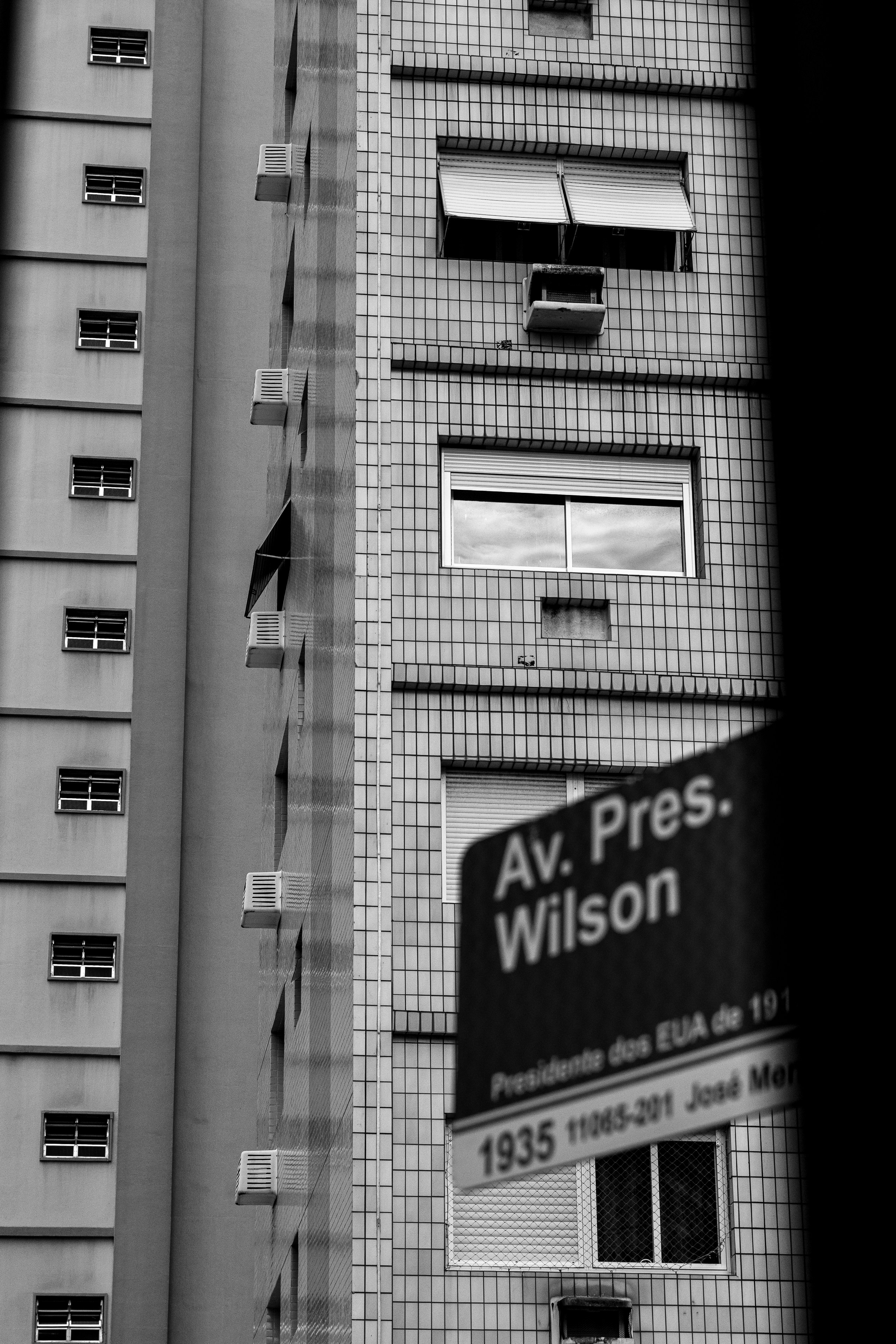 Tall building facade with windows and street sign