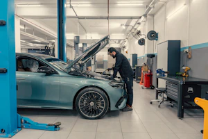 Mechanic working on a car engine in a workshop.