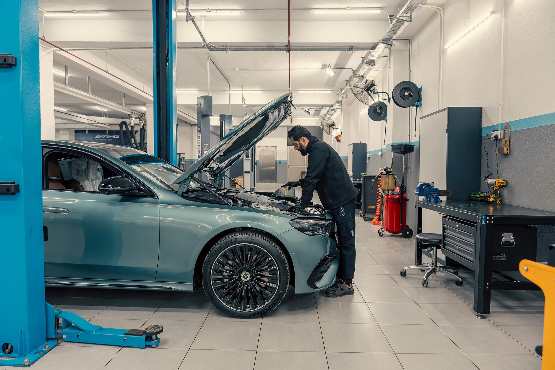 Mechanic working on a car engine in a workshop.