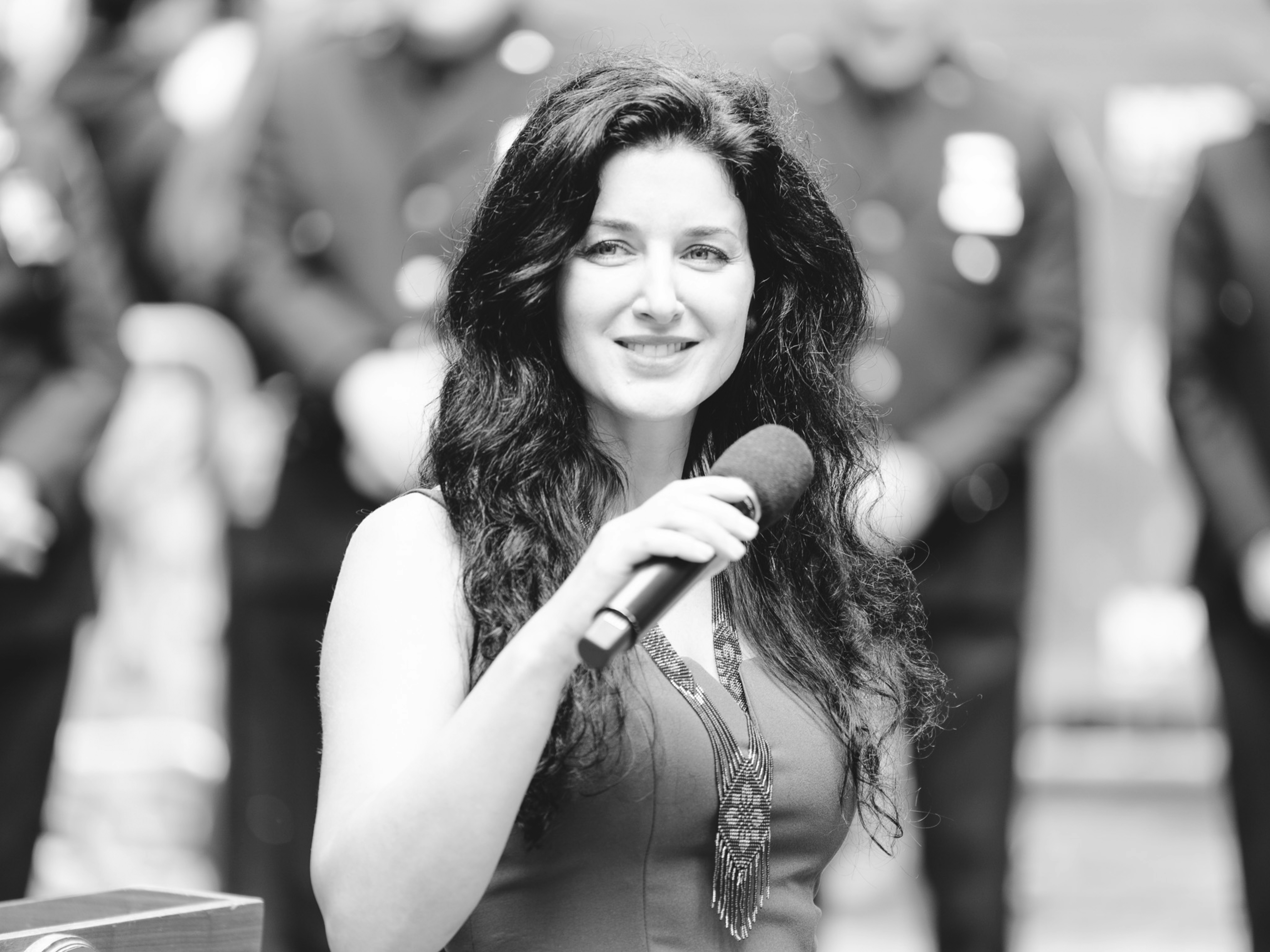 A woman holding a microphone and smiling