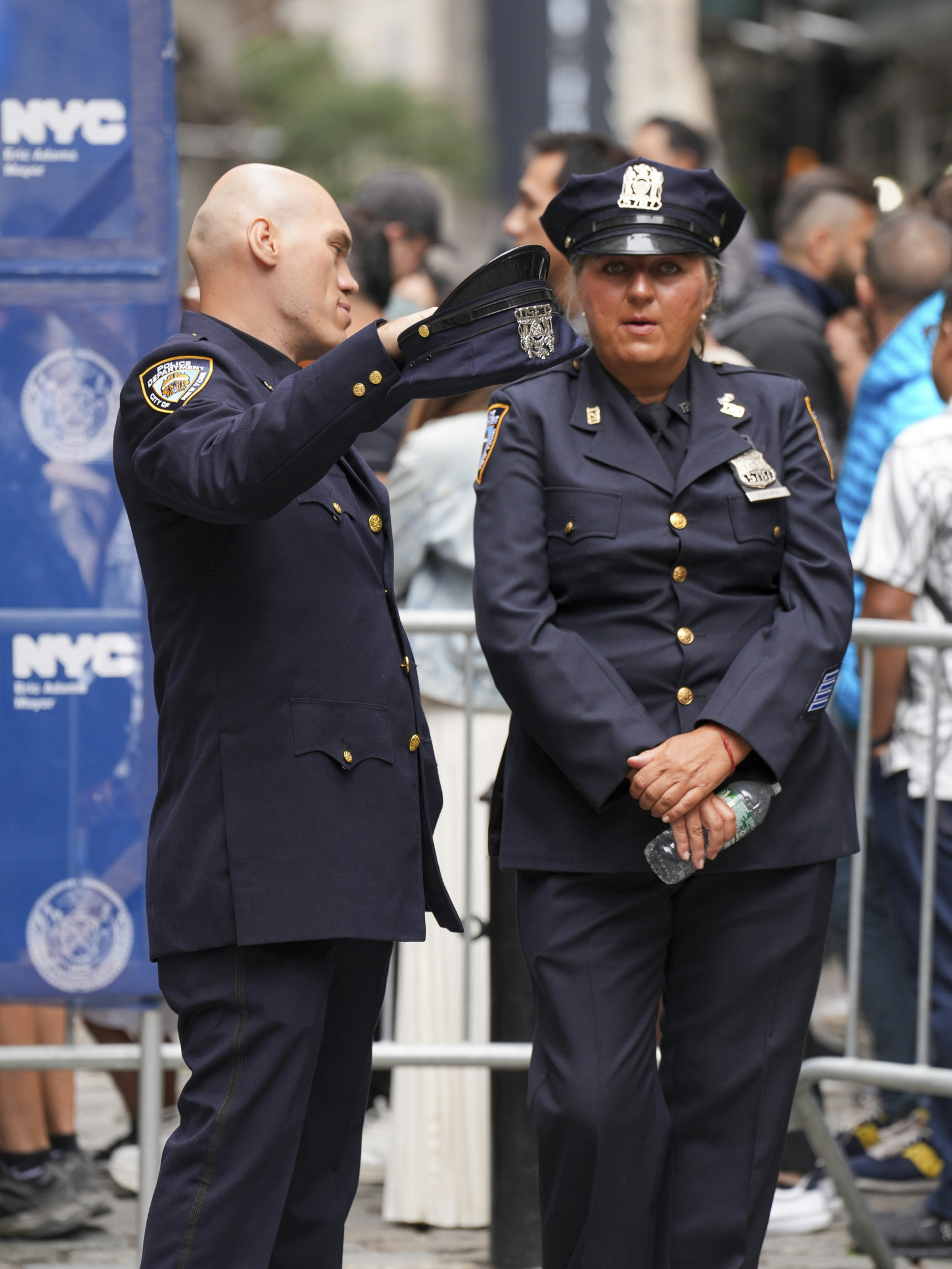 Two police officers in uniform standing outdoors.