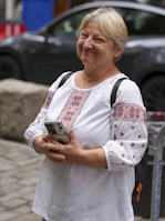 Woman in embroidered shirt holding a smartphone