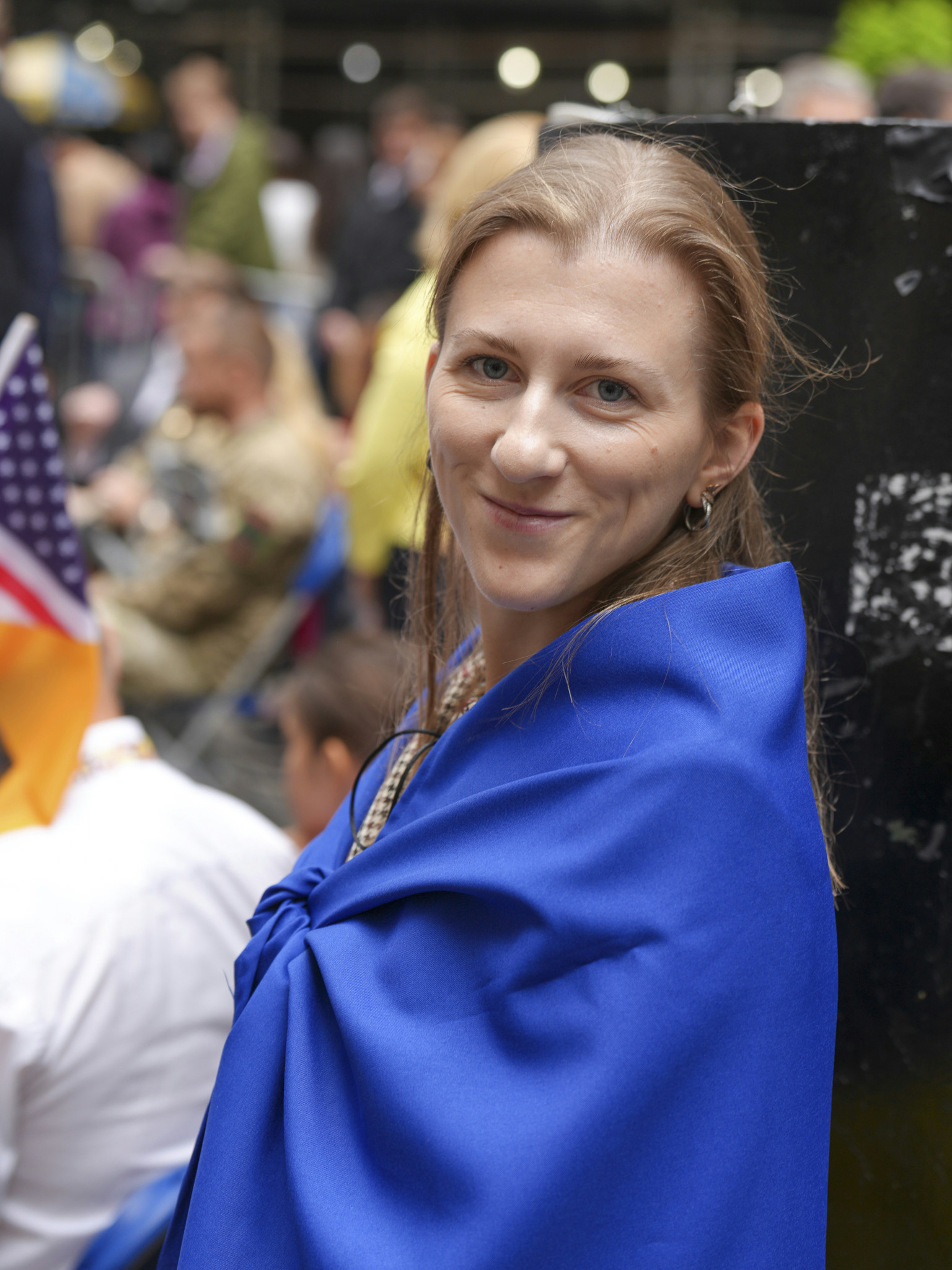 Woman draped in a blue cloth with a beaded necklace.