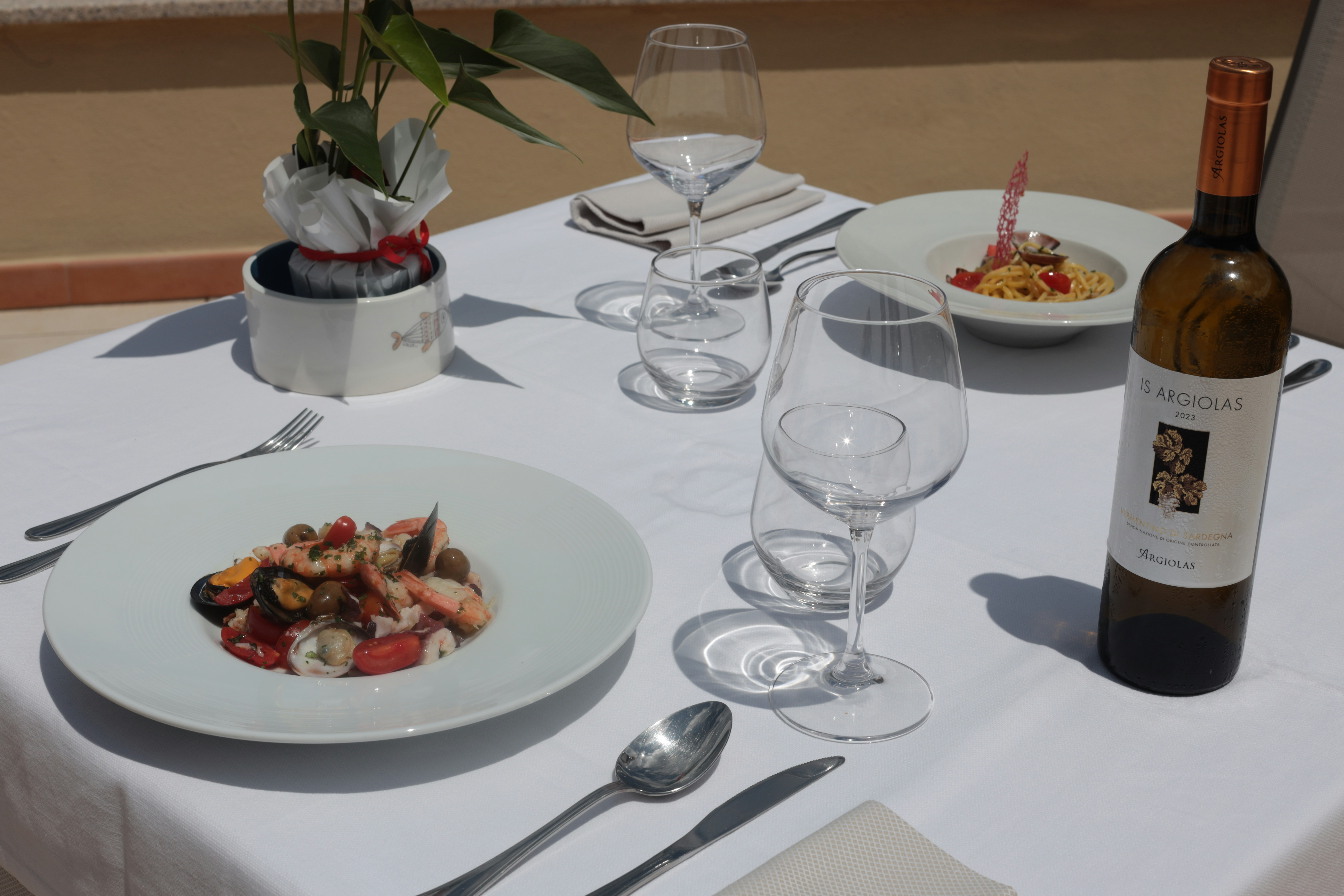 Una mesa puesta con dos platos de comida y vino.