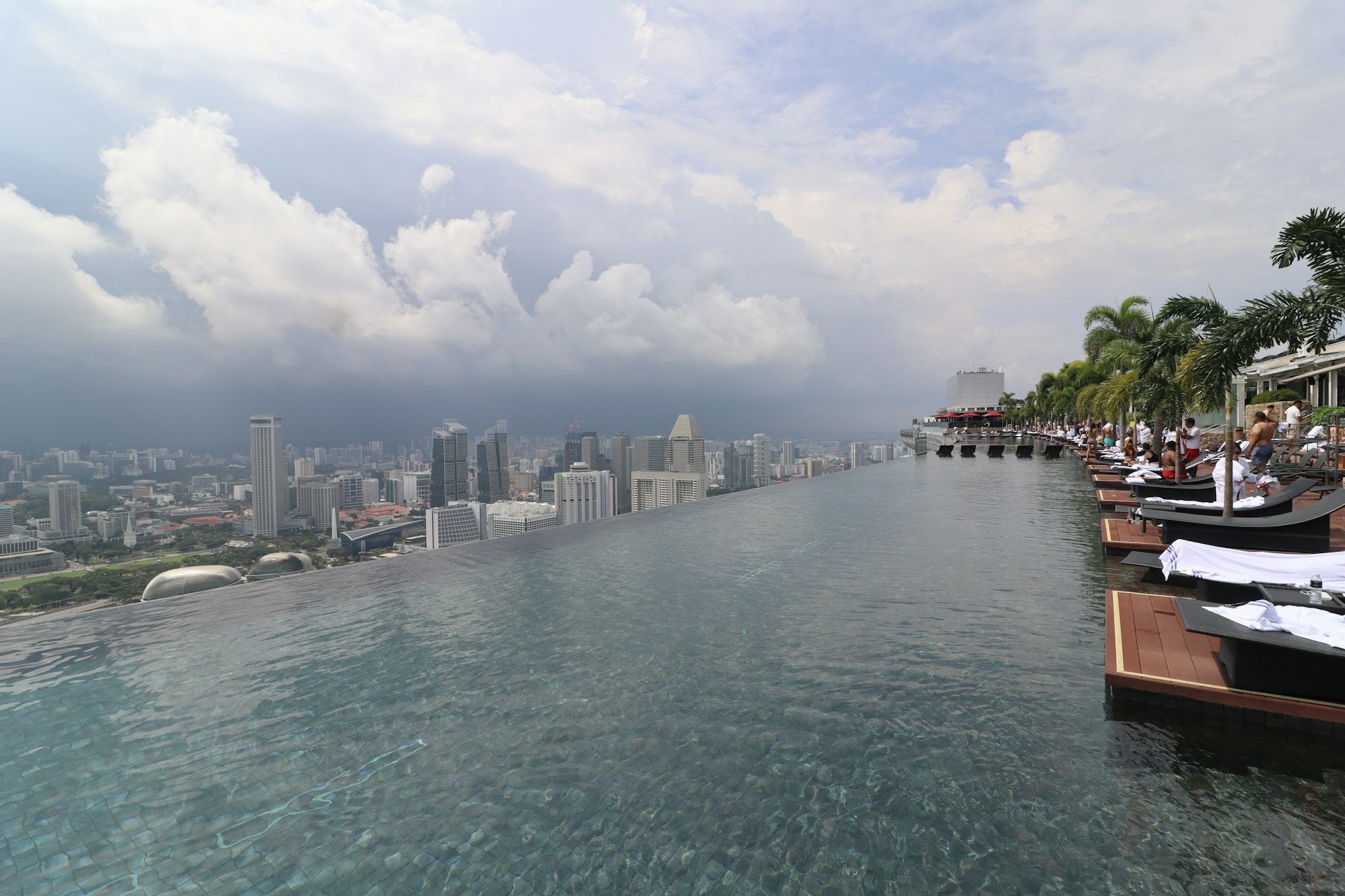 Infinity pool overlooking a cityscape under cloudy skies