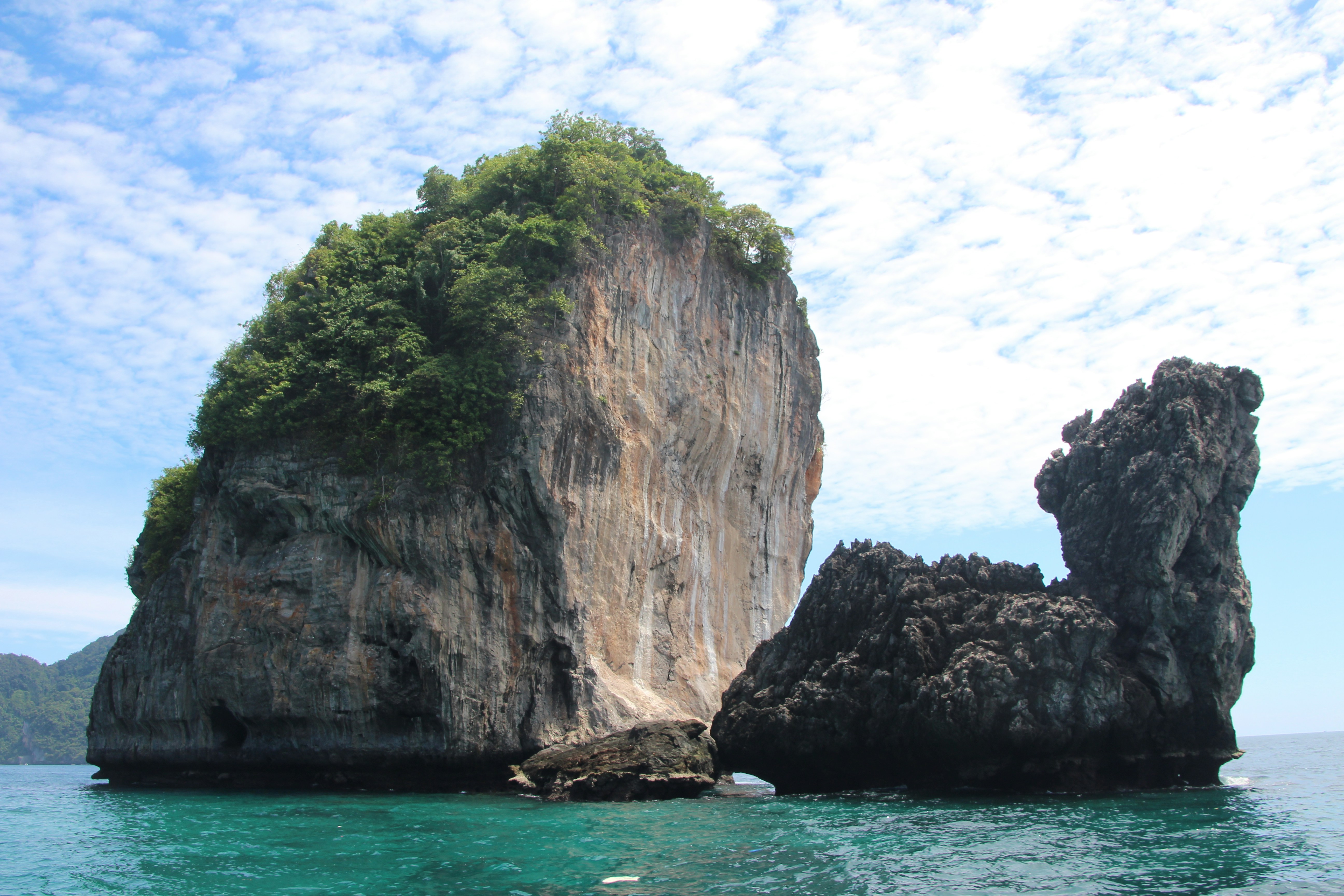 Dos grandes formaciones rocosas se elevan desde el océano turquesa.