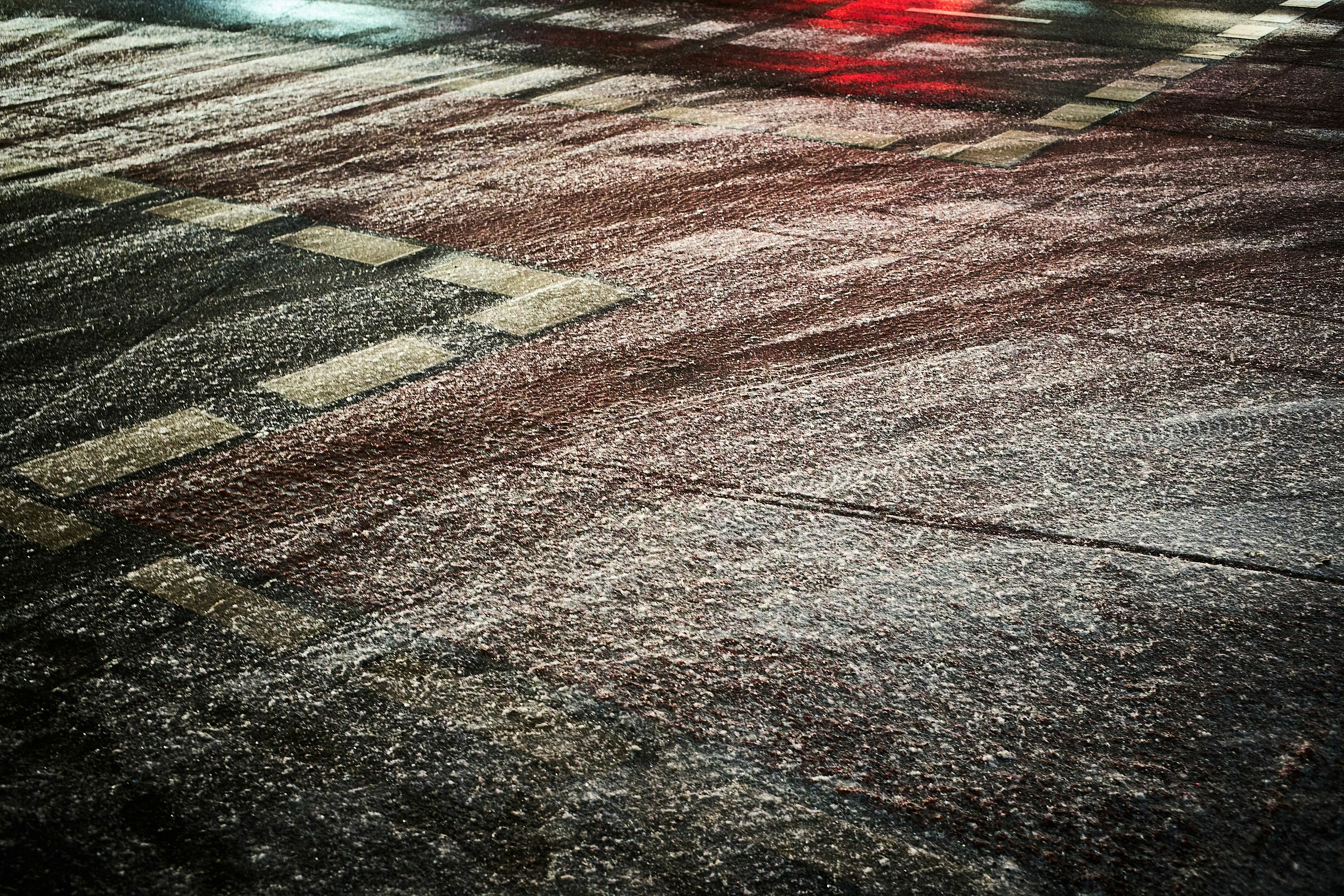 Wet street with tire tracks and reflections at night