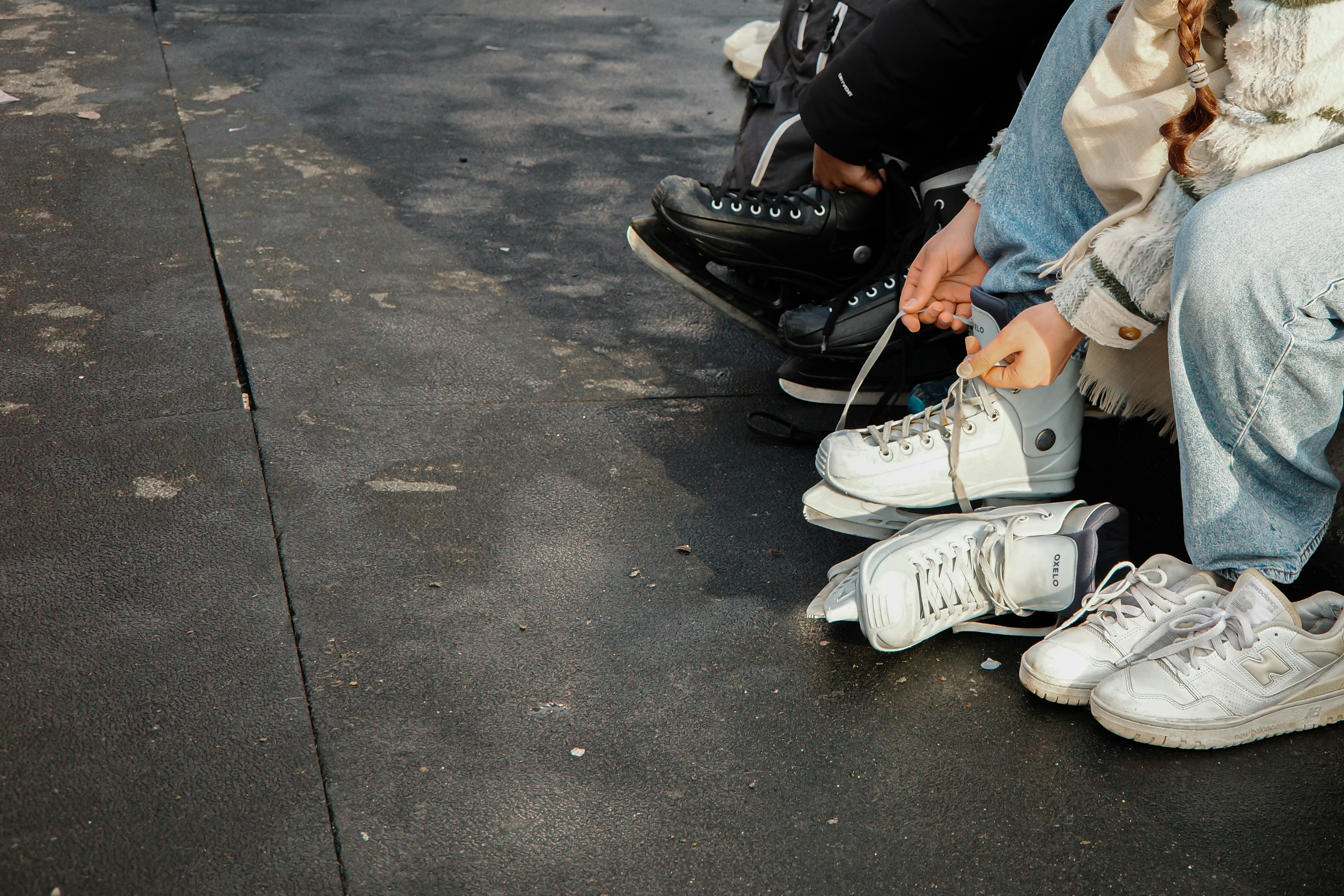 Gente sentada con patines de hielo y zapatillas