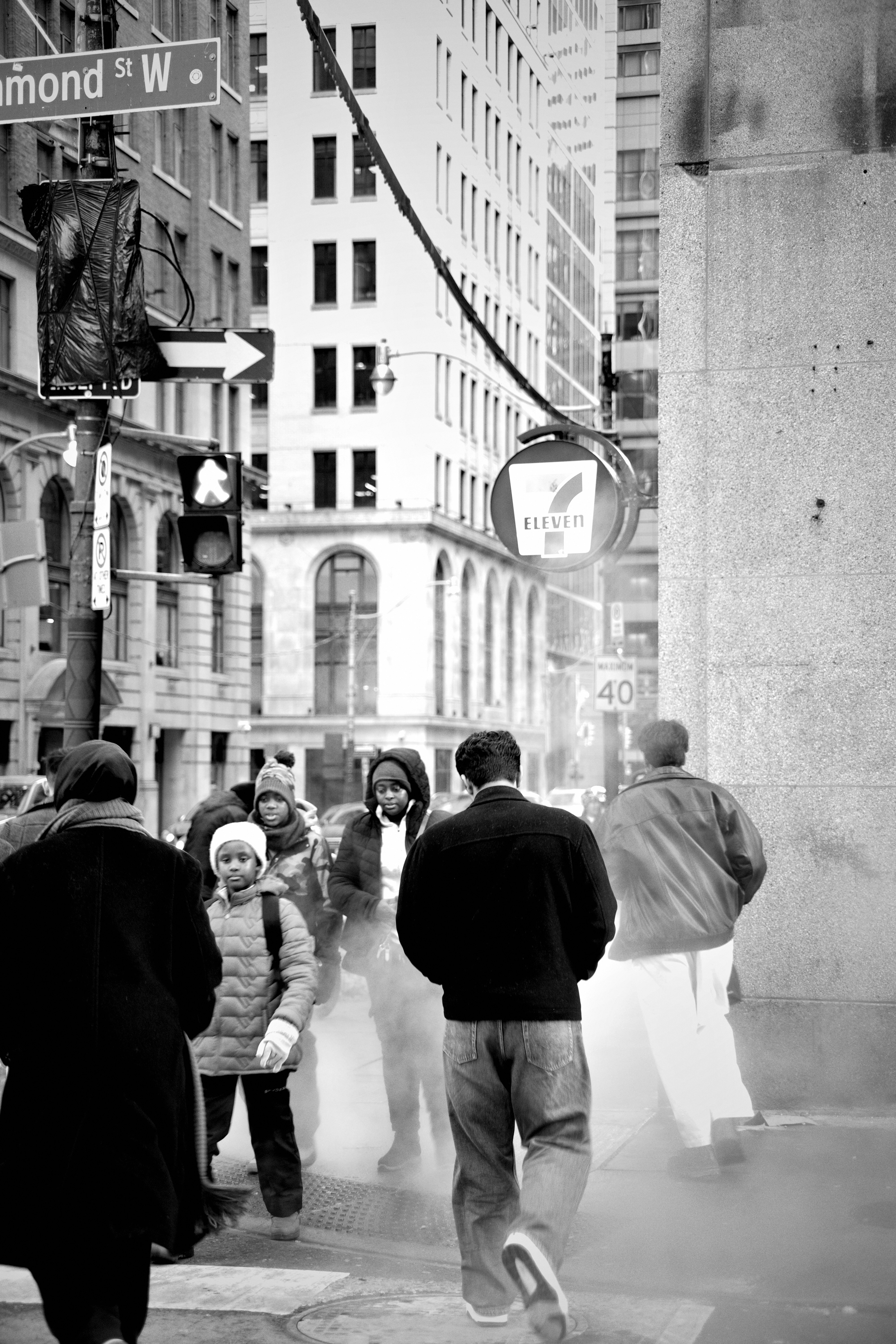 Gente caminando por una esquina brumosa de la ciudad.