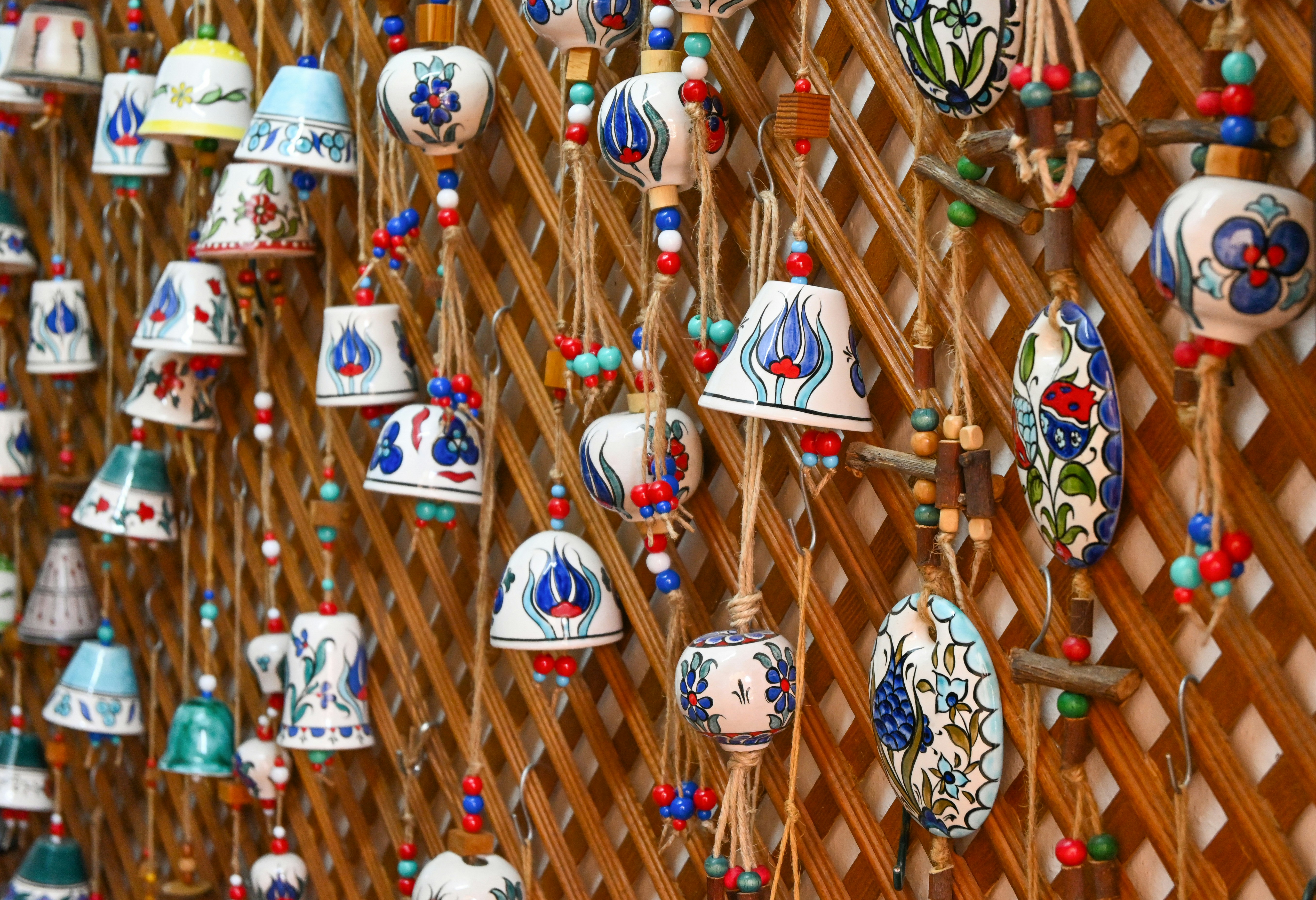 Hand-painted ceramic bells hanging on a wooden lattice