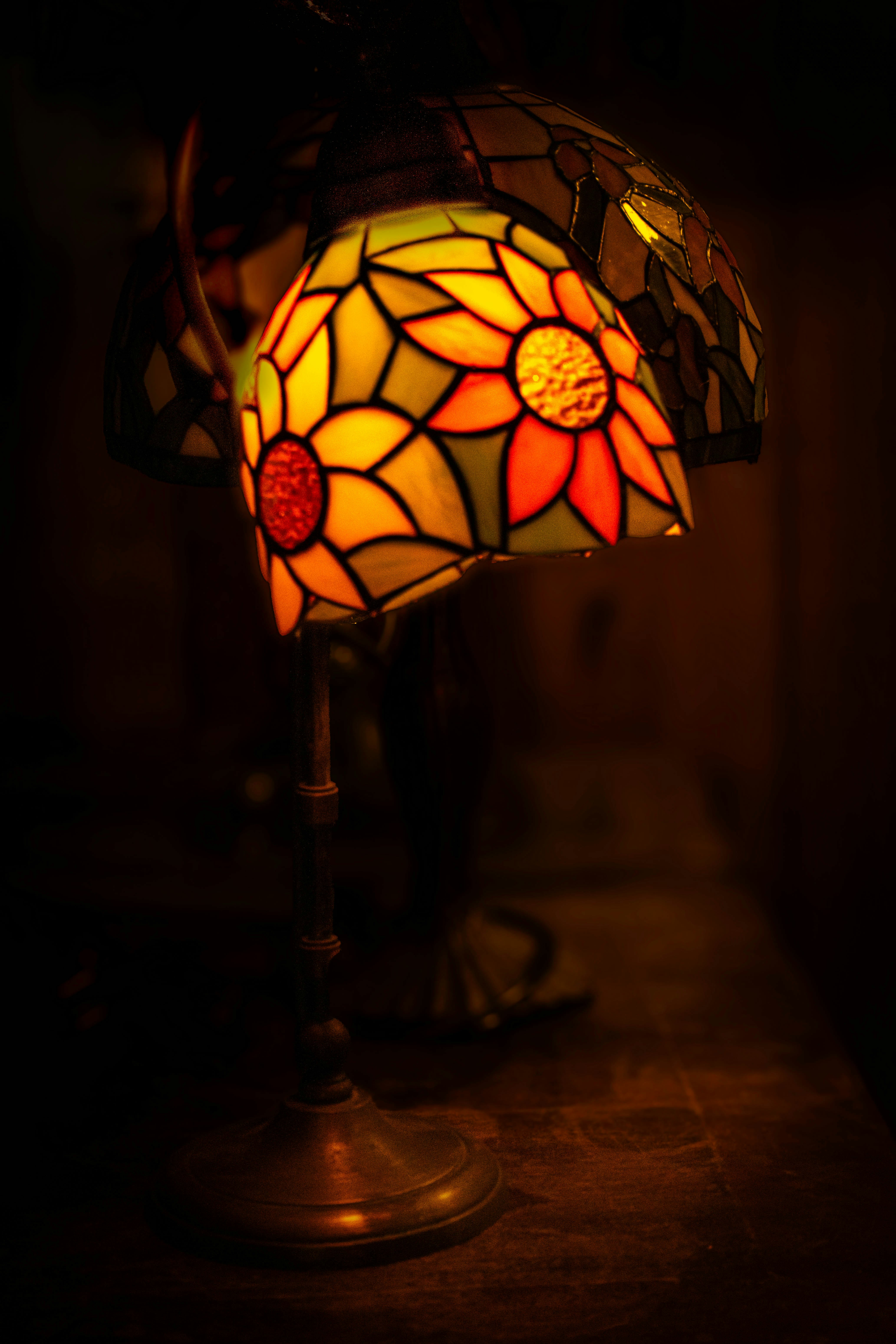 A tiffany style lamp with floral stained glass shade.