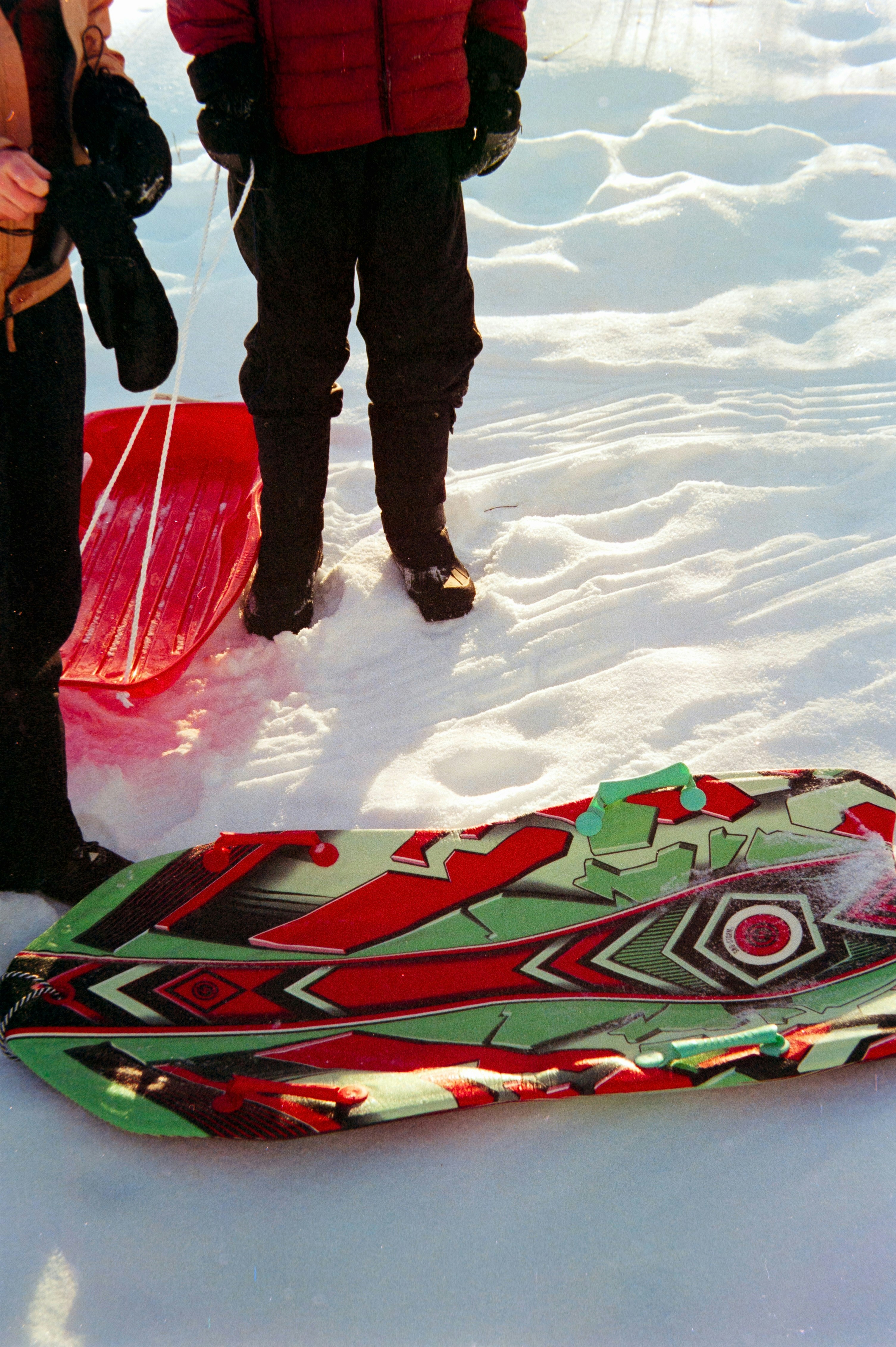 Two people with sleds in the snow