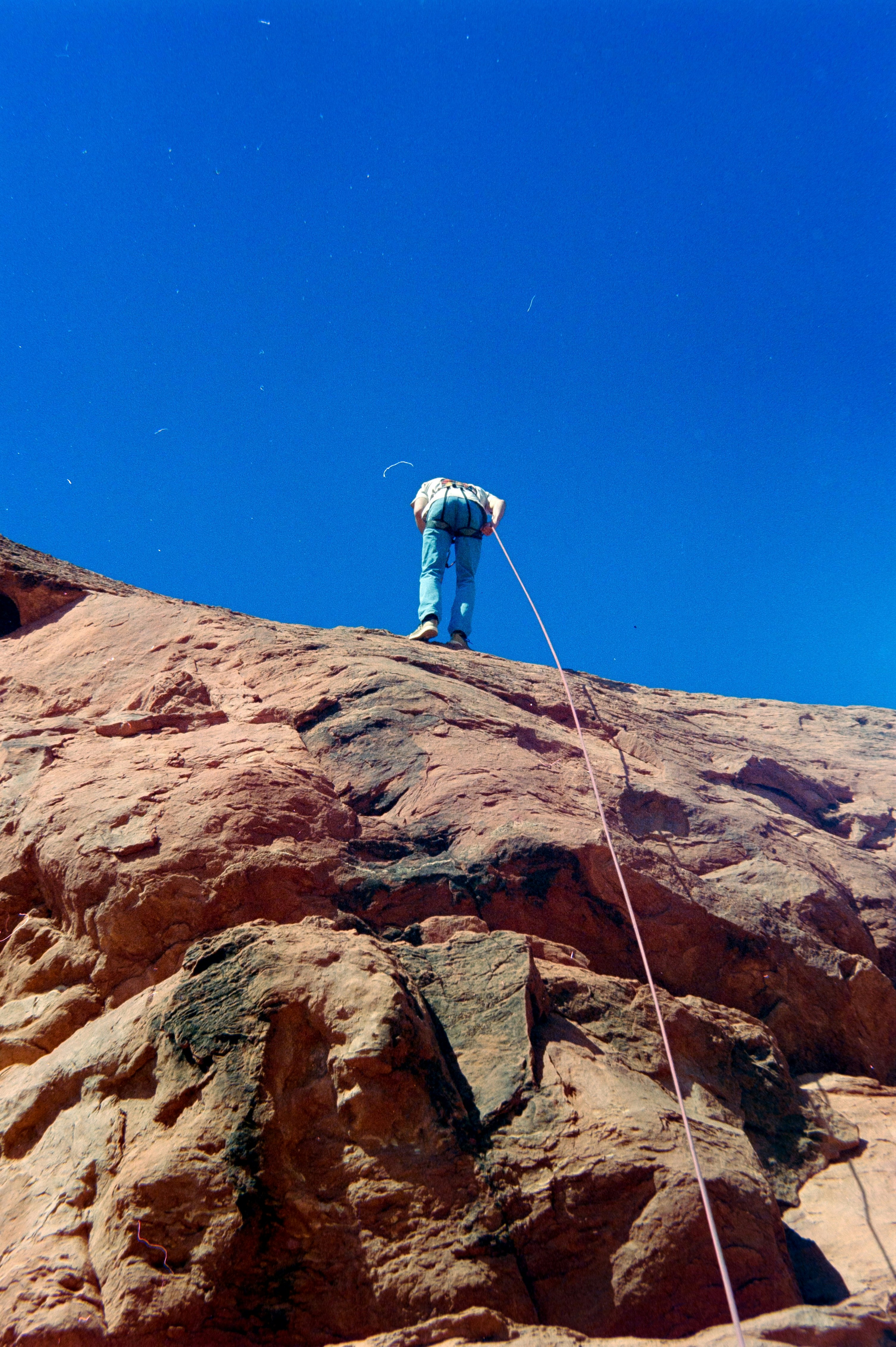 A rock climber rappels down a steep cliff face.