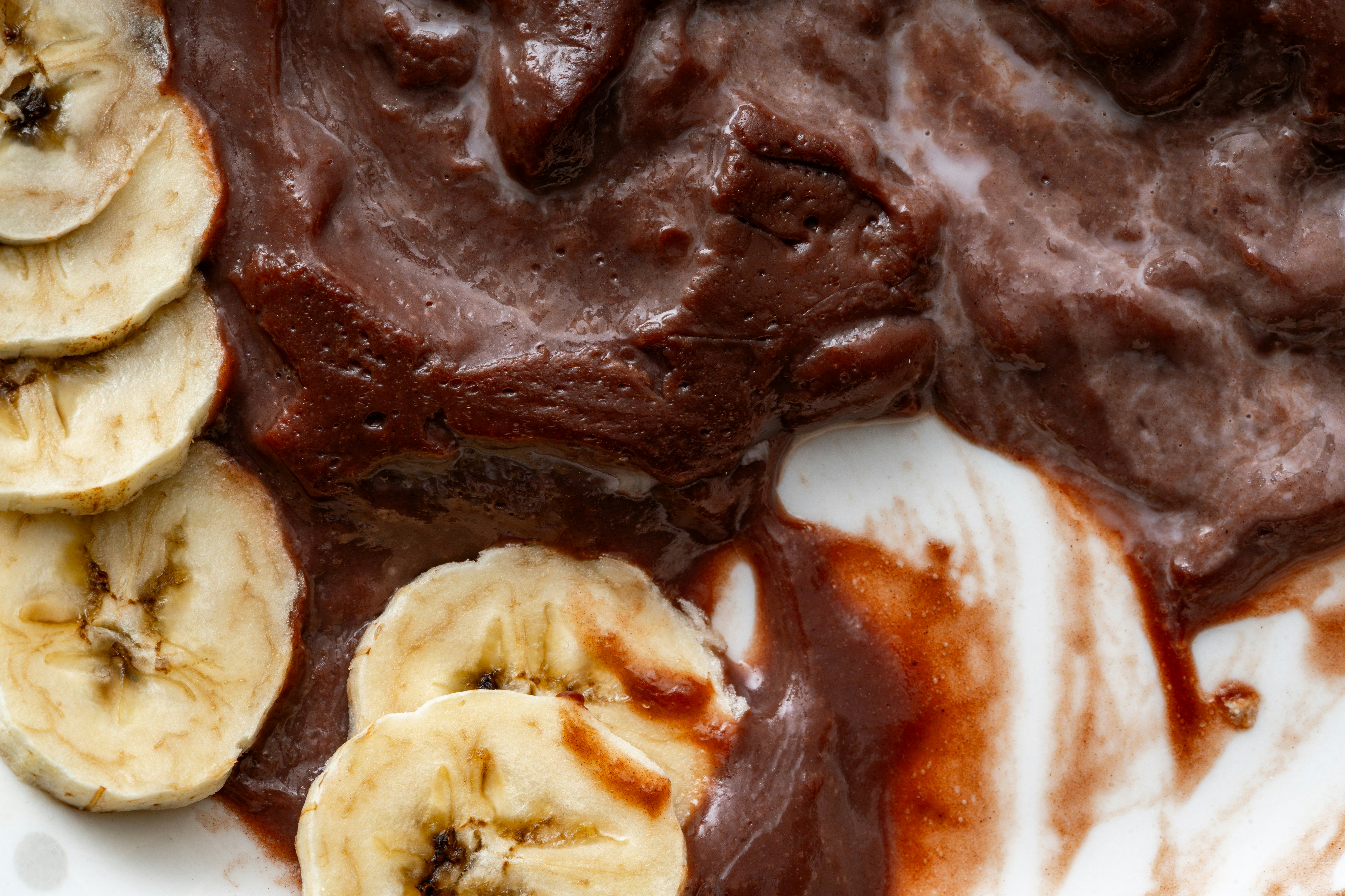 Açaí bowl with sliced bananas on a white plate