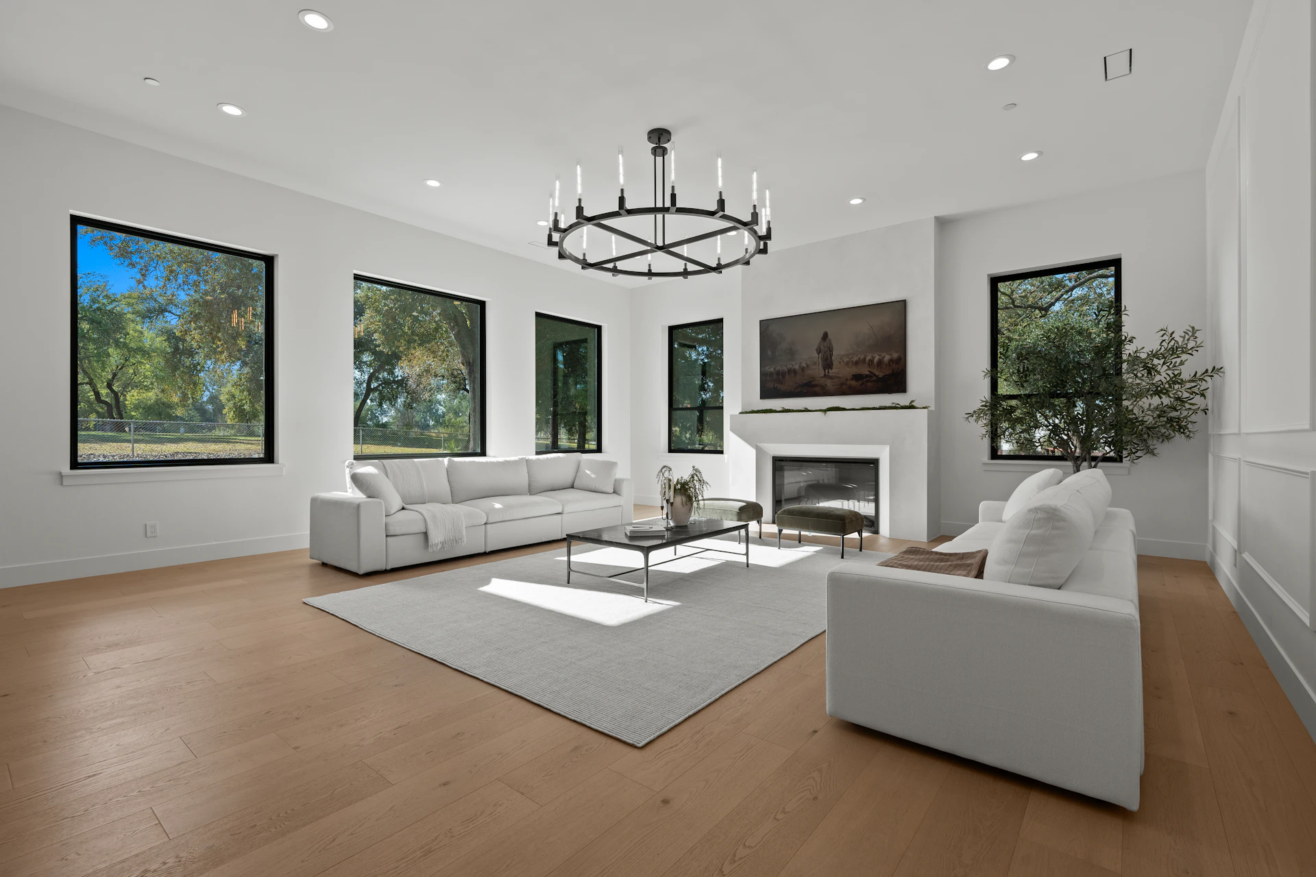 Spacious modern living room with white sofas and fireplace.
