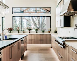 Modern kitchen with wood cabinets and large windows.