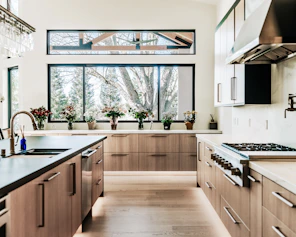 Modern kitchen with wood cabinets and large windows
