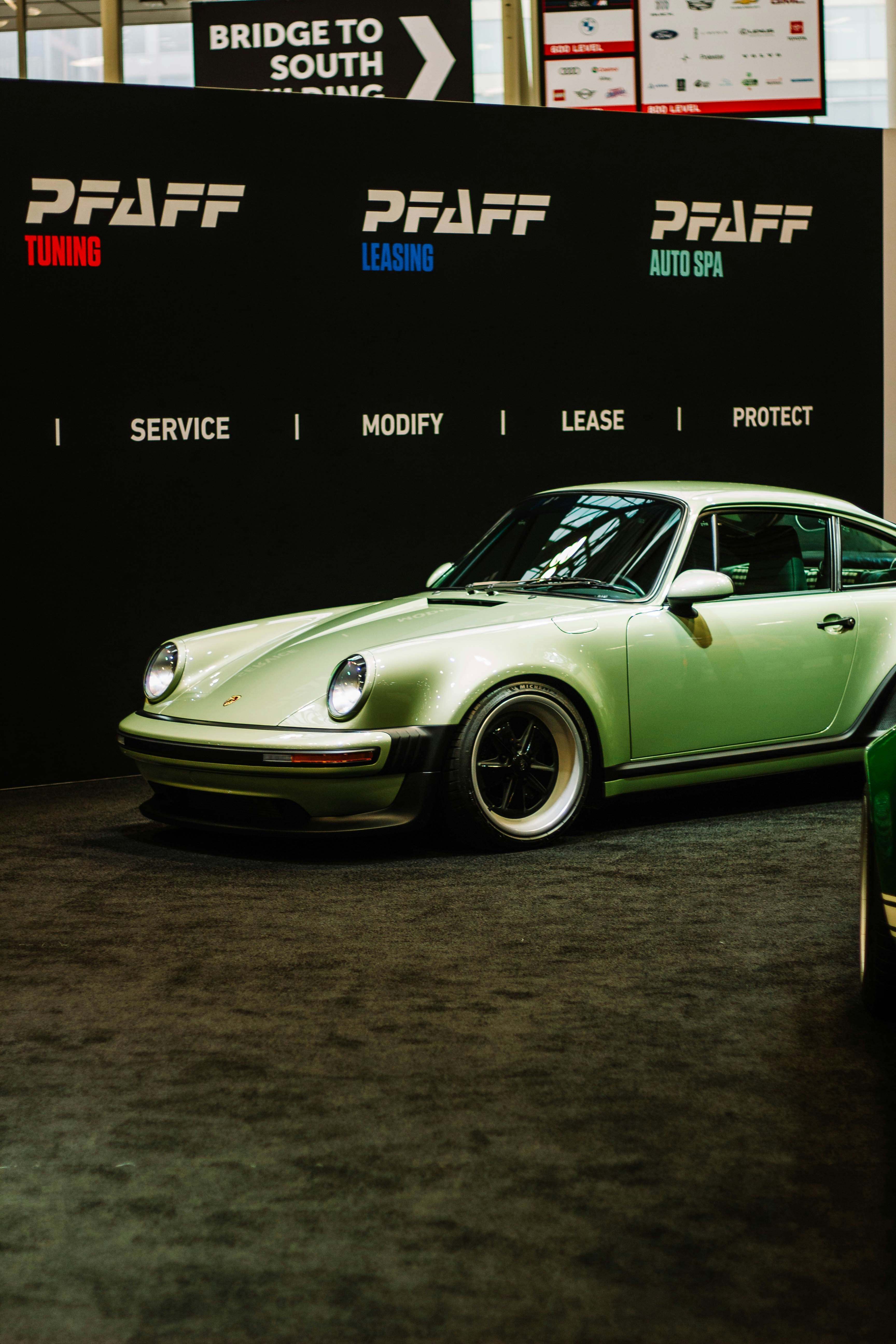 A light green vintage porsche 911 on display.
