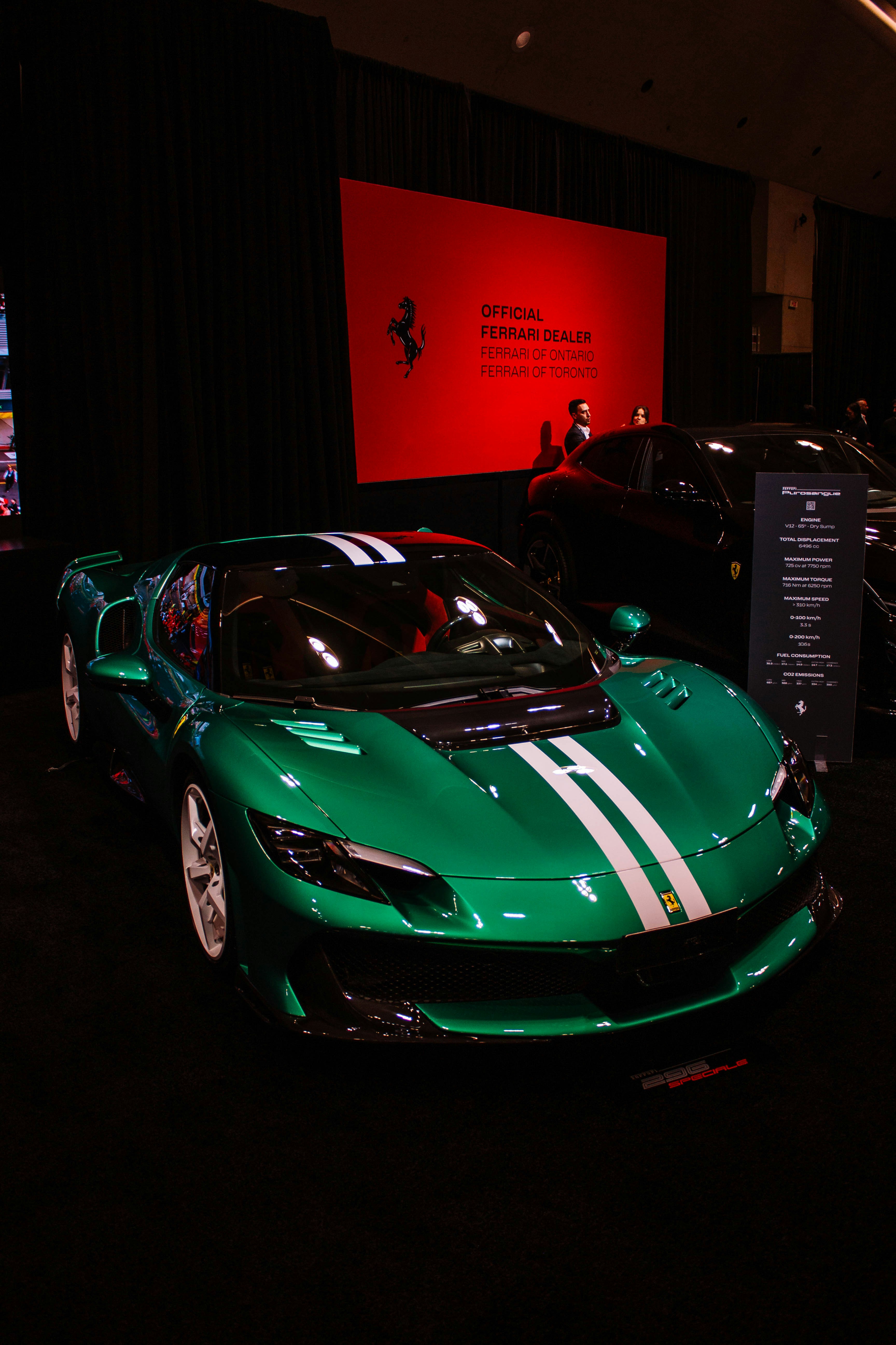 A sleek green sports car with white racing stripes