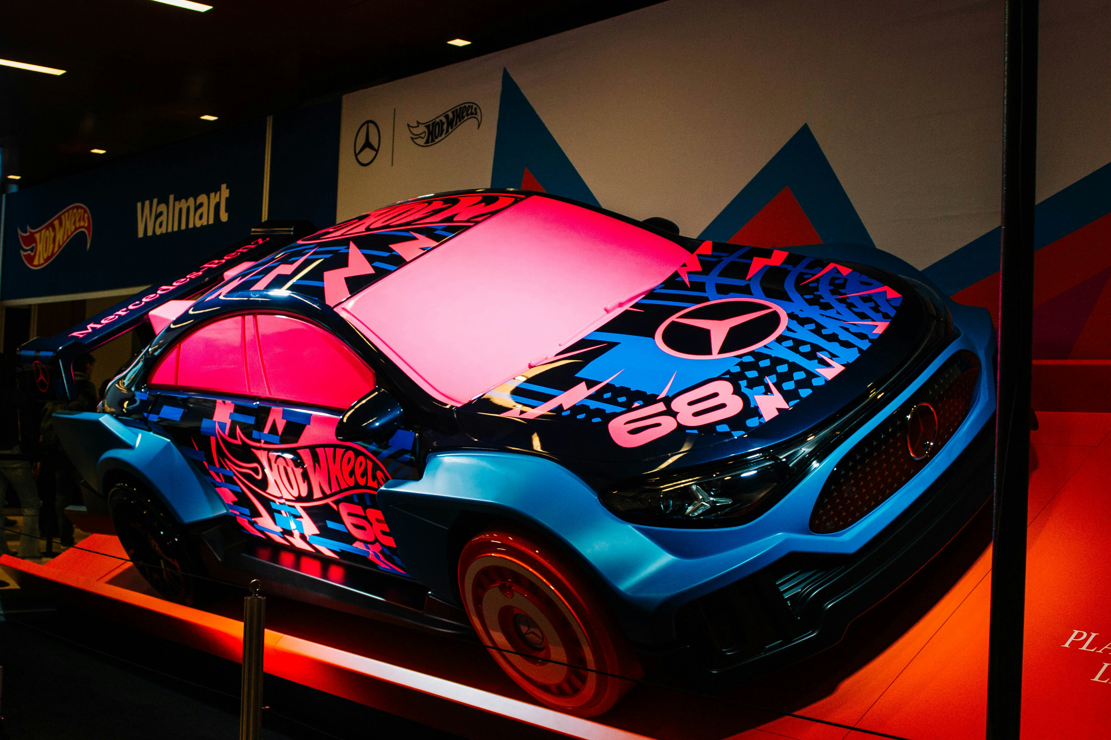 A custom car with vibrant blue and pink graphics.
