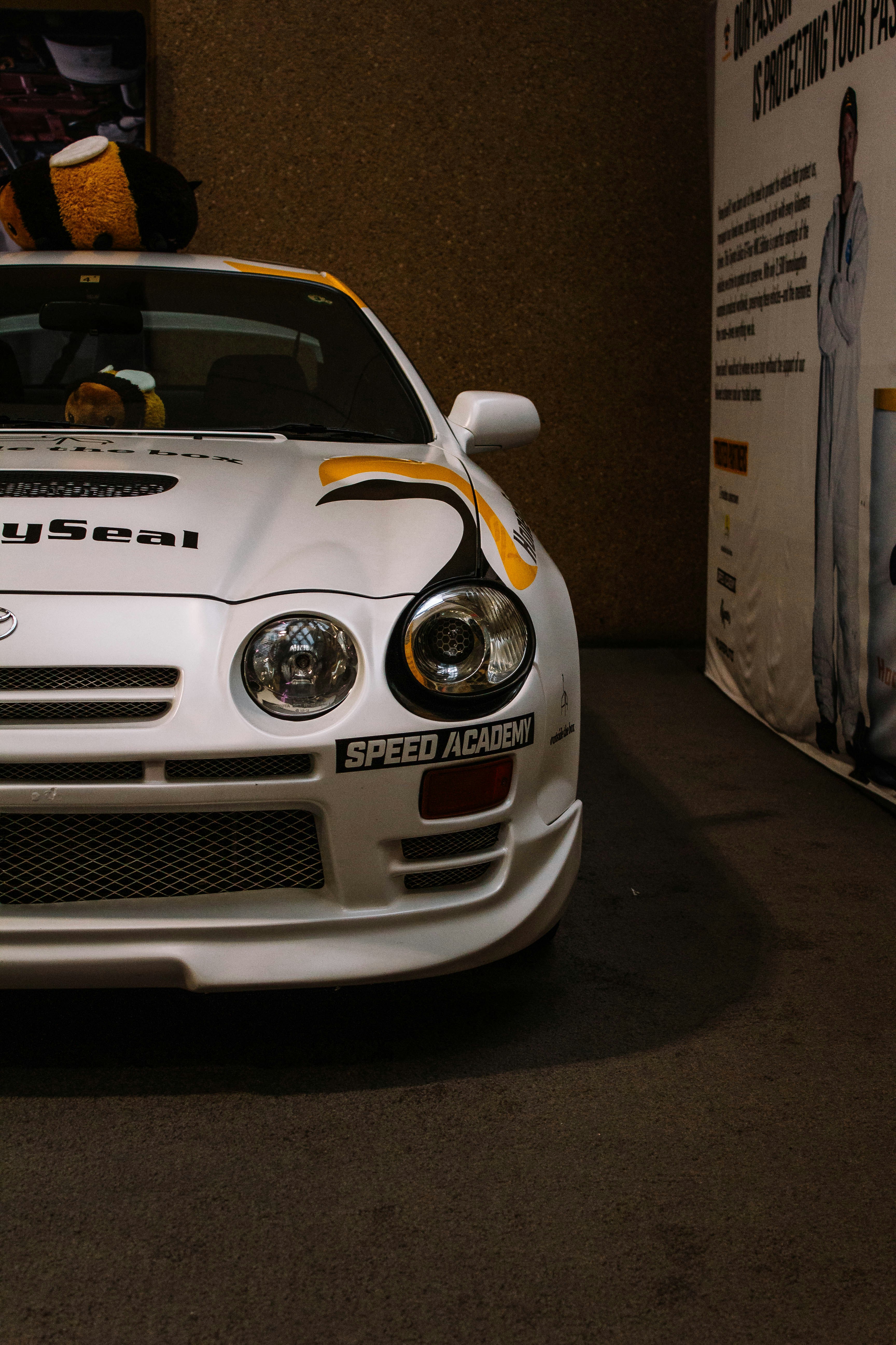 White race car with yellow accents and bumblebee toy