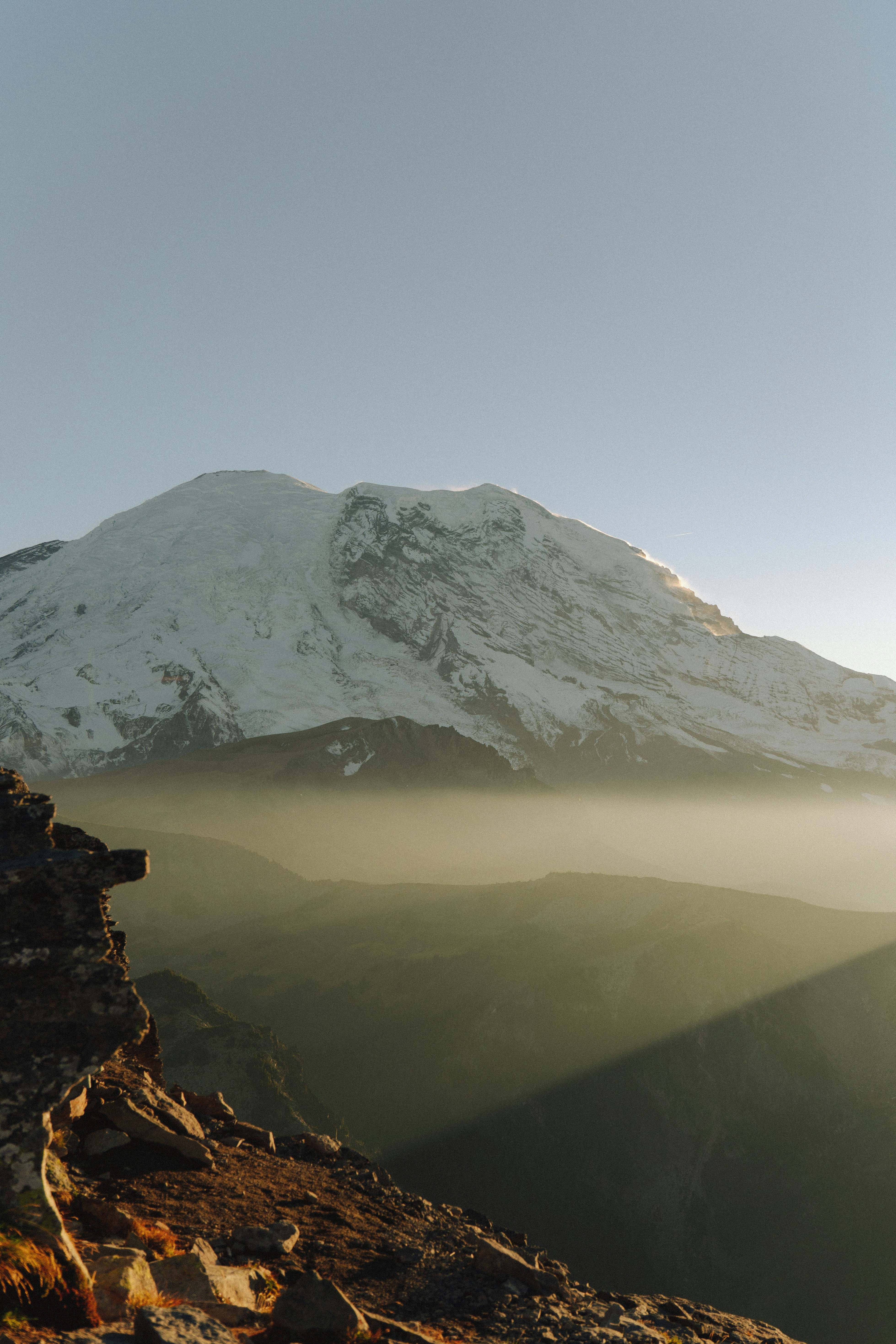 Snow-capped mountain peak bathed in soft sunlight.